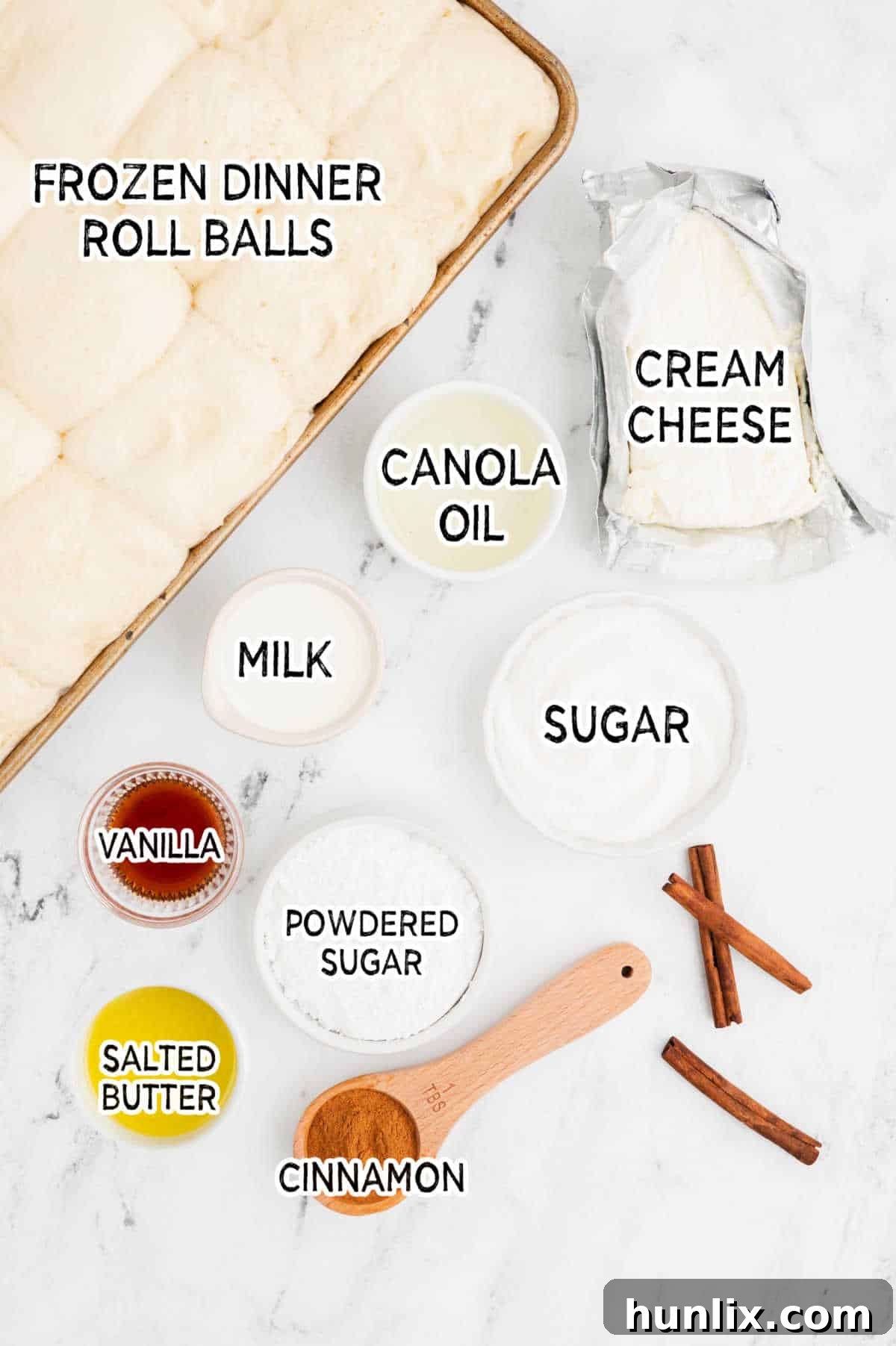 Ingredients for air fryer cinnamon twists and cream cheese dip on a white marble counter.