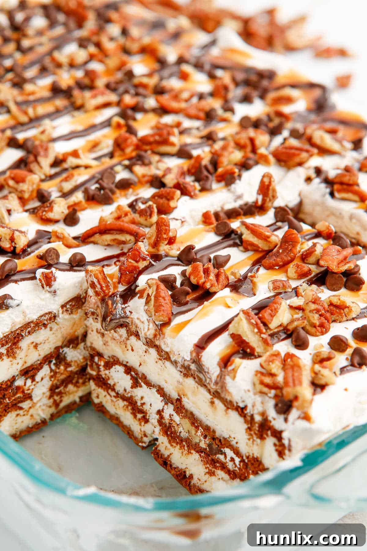 The Turtle Ice Cream Sandwich Cake in its baking pan, with one slice already removed, showing the clean layers.