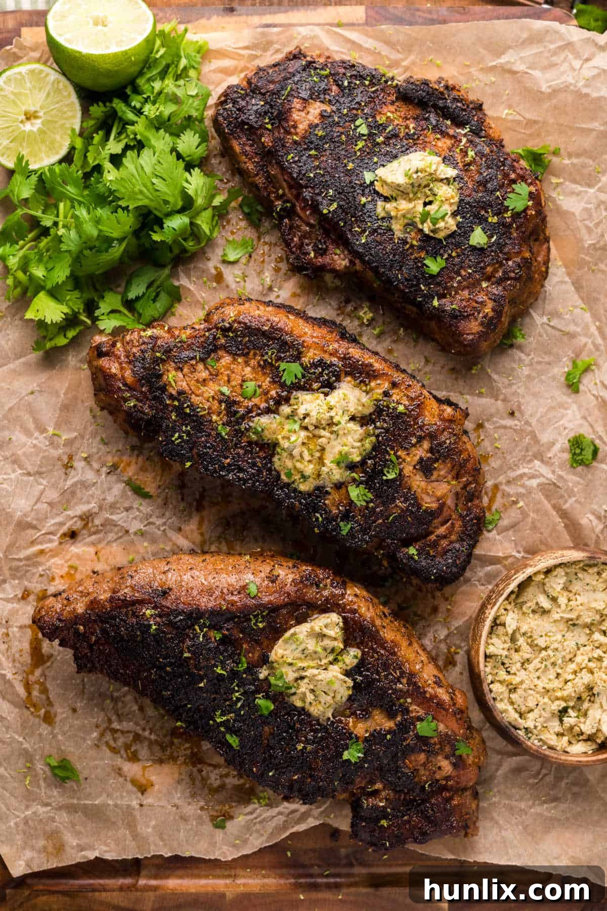 Blackened steaks on a piece of parchment paper.