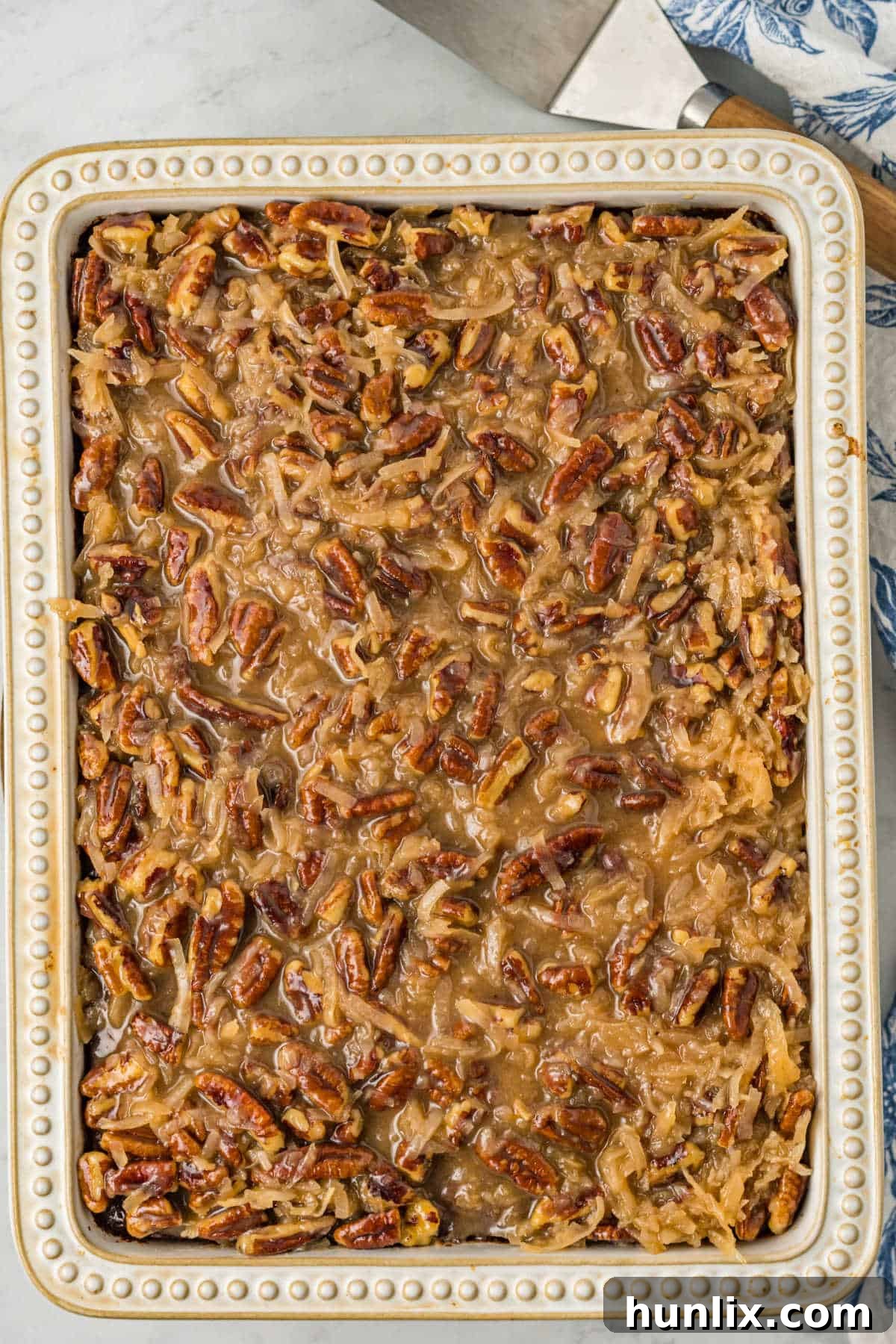 A pan of delicious Tornado Cake, freshly baked and topped with coconut and pecans.