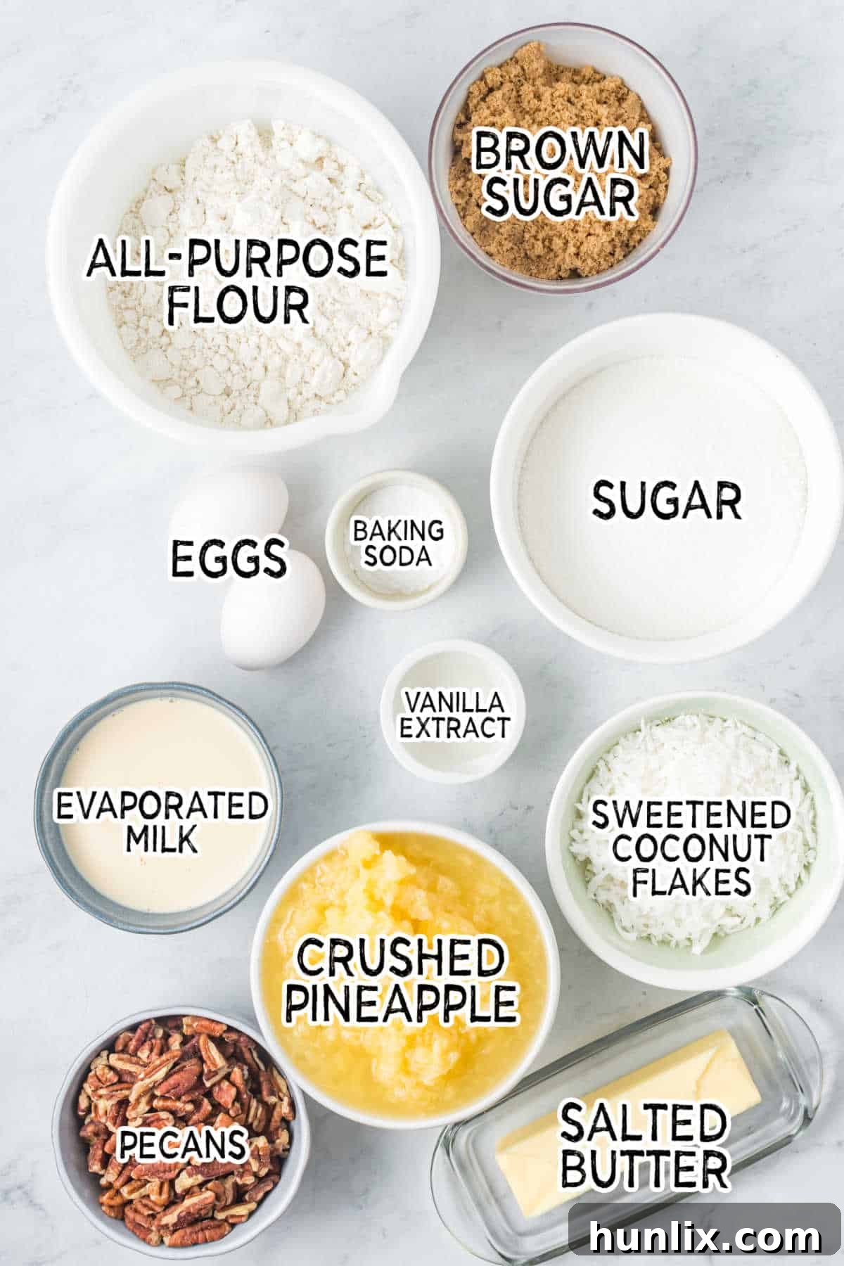 Assortment of fresh ingredients for Tornado Cake arranged on a white marble background.