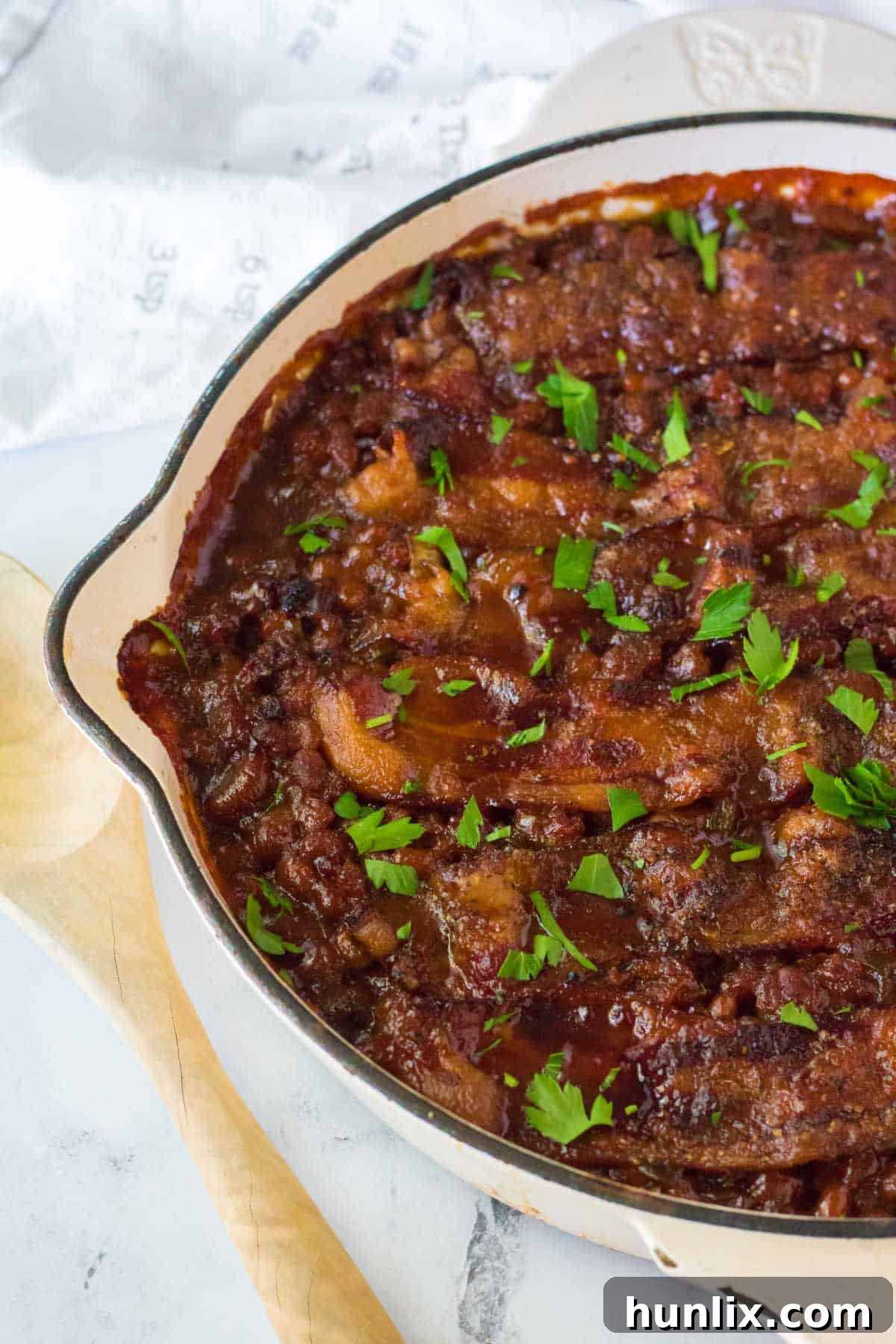 Close-up of a serving of baked beans with ground beef and bacon, ready to be enjoyed as a hearty meal.