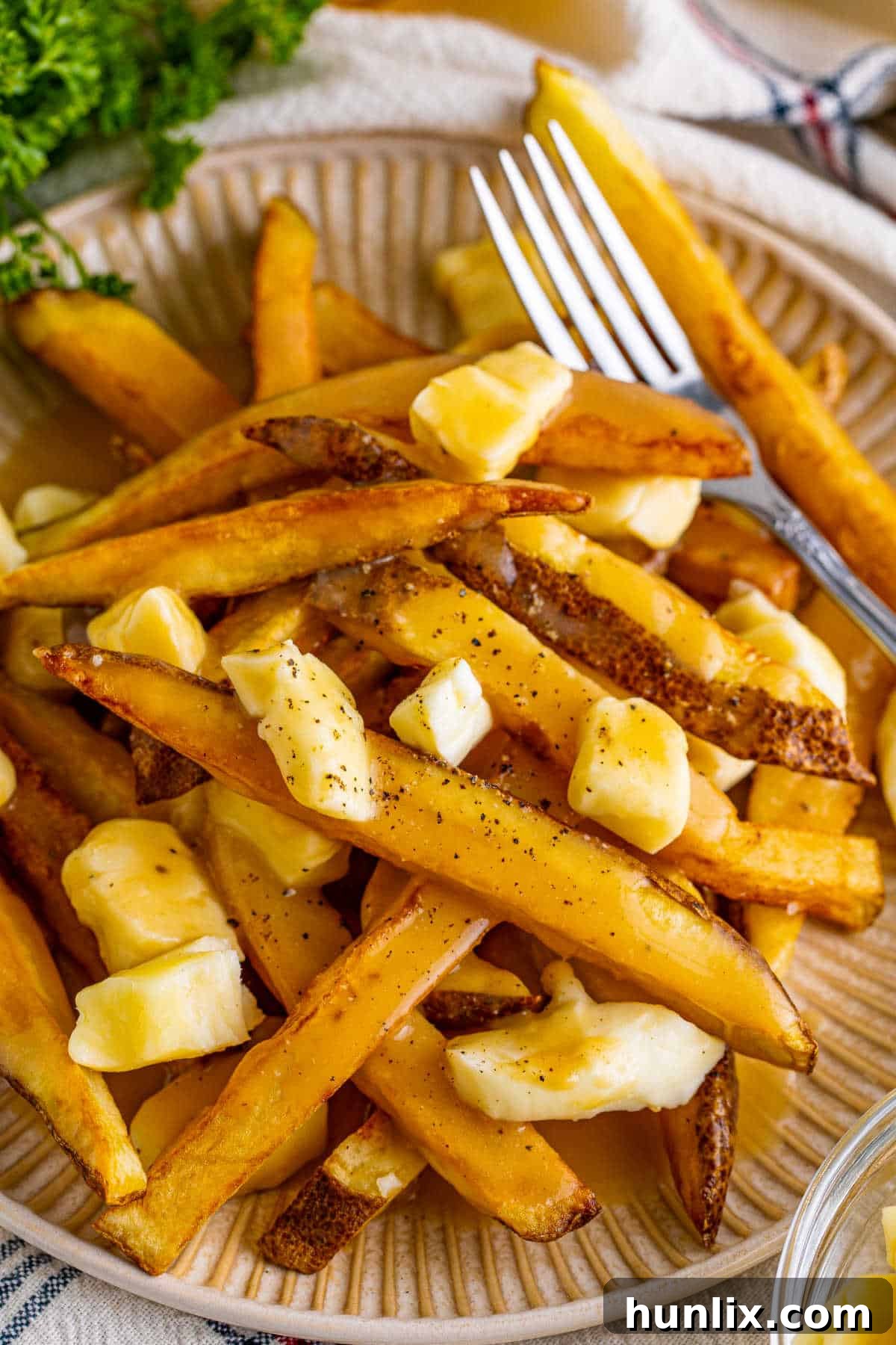 Canada's Iconic Comfort Food 7 A fork piercing into a delicious serving of poutine, showing the blend of fries, gravy, and curds.