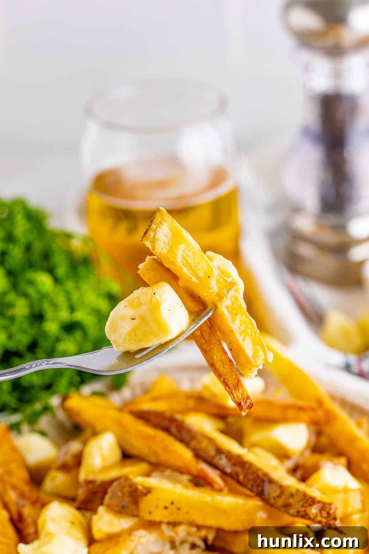Canada's Iconic Comfort Food 9 A close-up shot of a fork lifting a piece of poutine, showing the texture and components.
