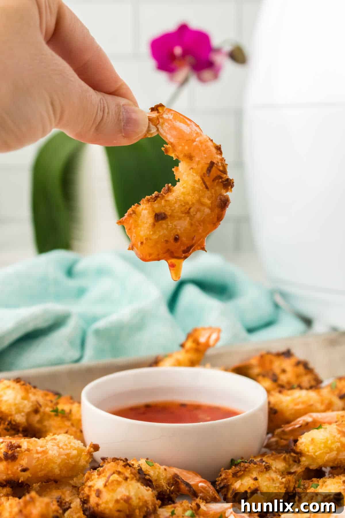 A hand holding up a shrimp.
