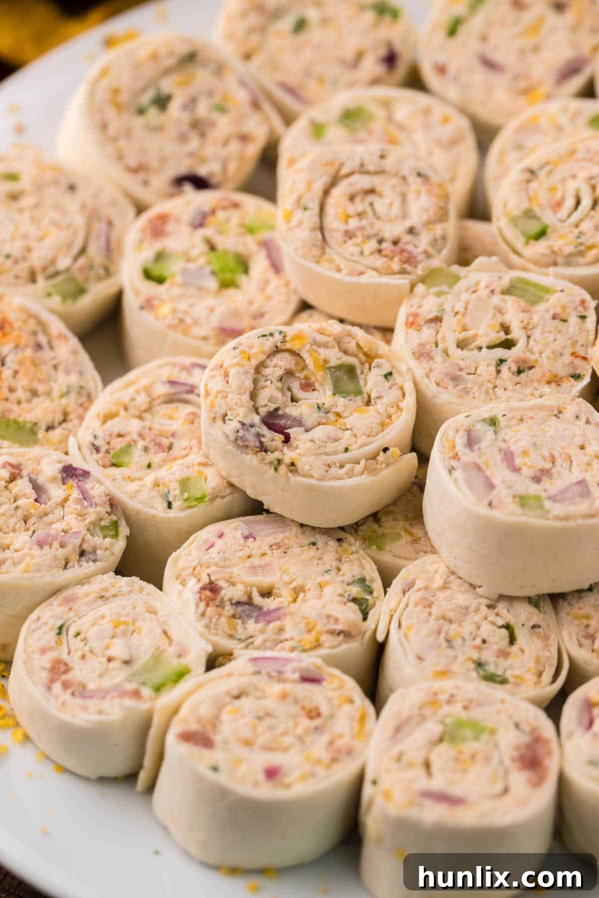 A single chicken pinwheel neatly sliced and presented on a small white plate.