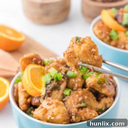 A bowl of Orange Chicken, garnished and ready to serve.