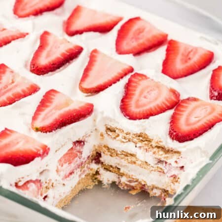 The Strawberry Icebox Cake in a pan with a slice cut out, showcasing the vibrant layers.