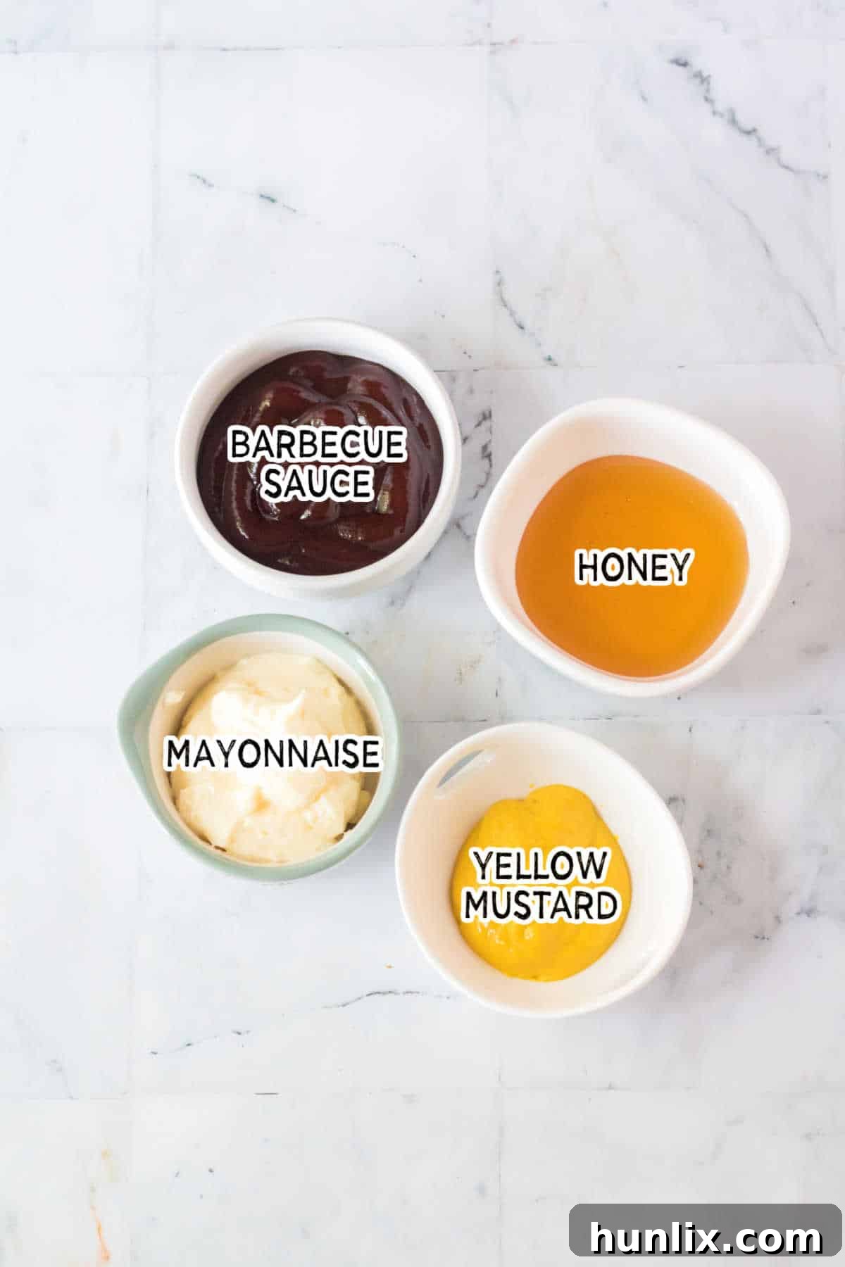 The Ultimate Homemade Chick-fil-A Nuggets 5 A collection of ingredients laid out for making Chick-fil-A sauce, including mayonnaise, mustard, barbecue sauce, and honey.