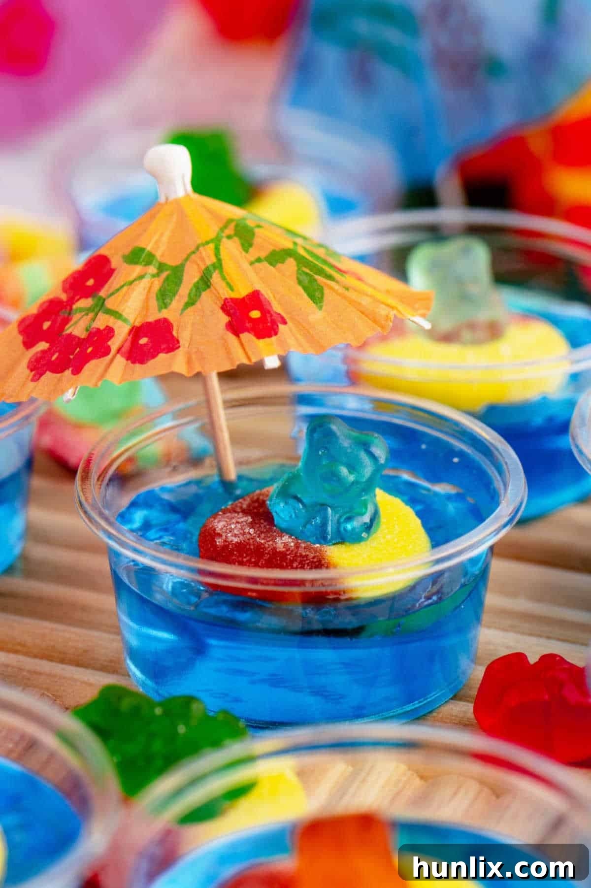 A festive Pool Party Jello Shot adorned with a tiny cocktail umbrella, creating a perfect mini summer scene.