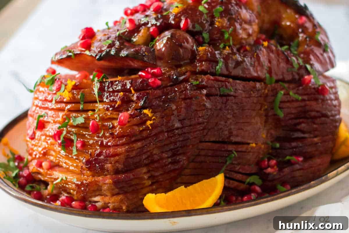 Christmas Glazed Ham 8 A beautifully sliced Christmas ham with glaze and garnishes, served on a platter, ready for holiday dining.
