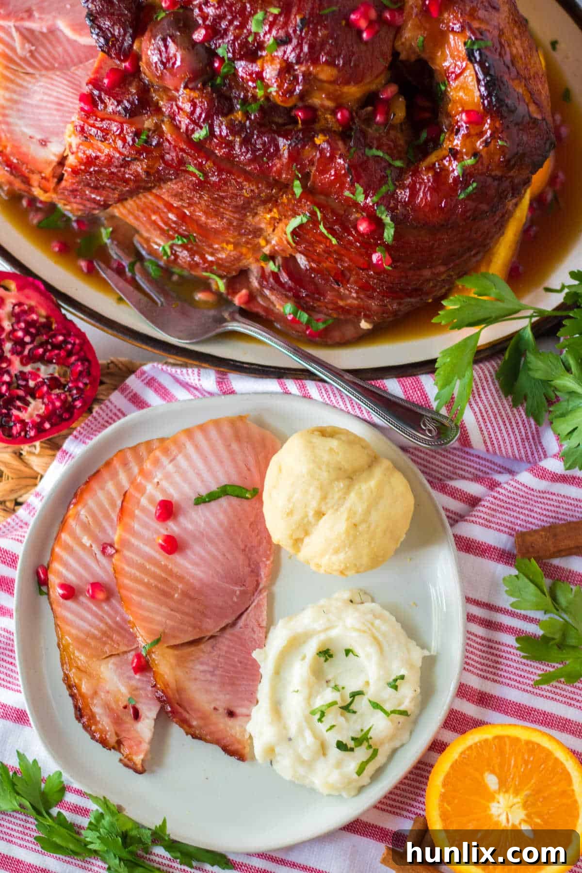 Christmas Glazed Ham 9 A plate of sliced Christmas ham served with creamy mashed potatoes and a dinner roll, ready for a delicious meal.