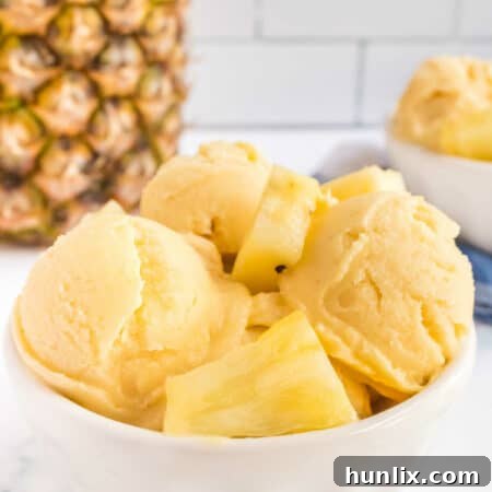 Creamy pineapple ice cream with a spoon.