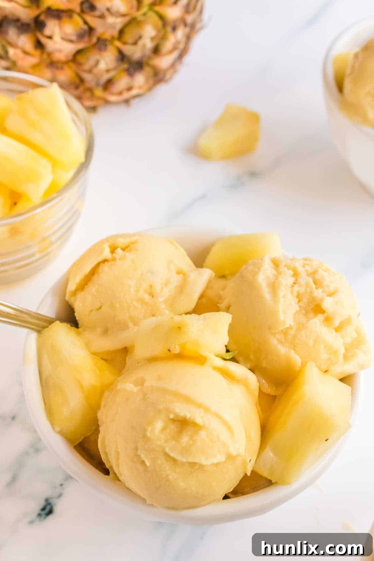 Pineapple Ice Cream in a bowl with a spoon.