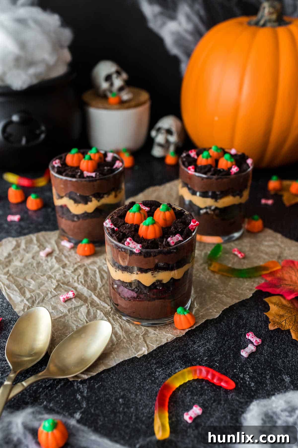 Pumpkin Patch Pudding Pots 6 Three pumpkin patch dirt cups among Halloween decor.