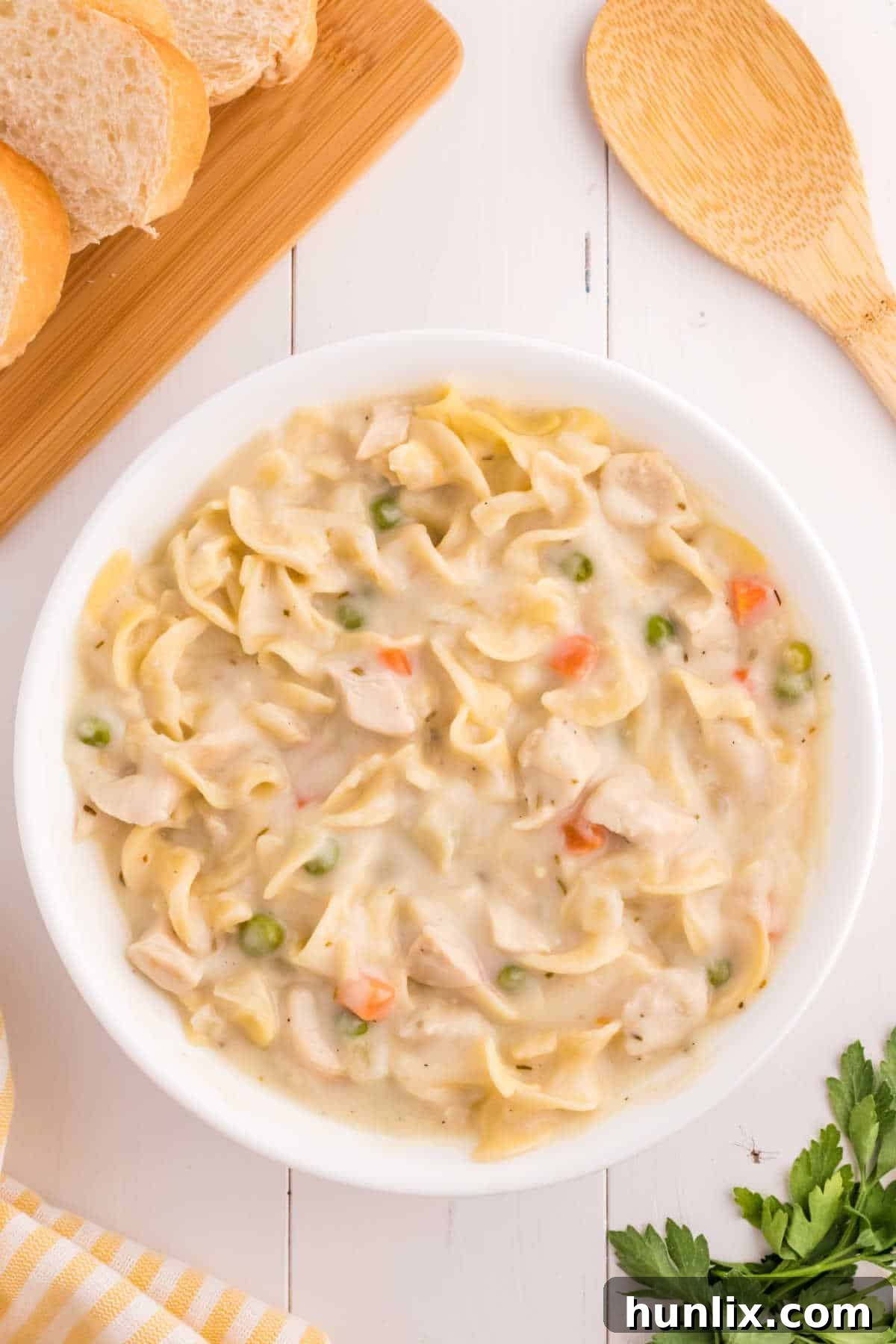 A beautifully presented bowl of creamy chicken noodle soup, garnished with fresh herbs, perfect for a cozy meal.