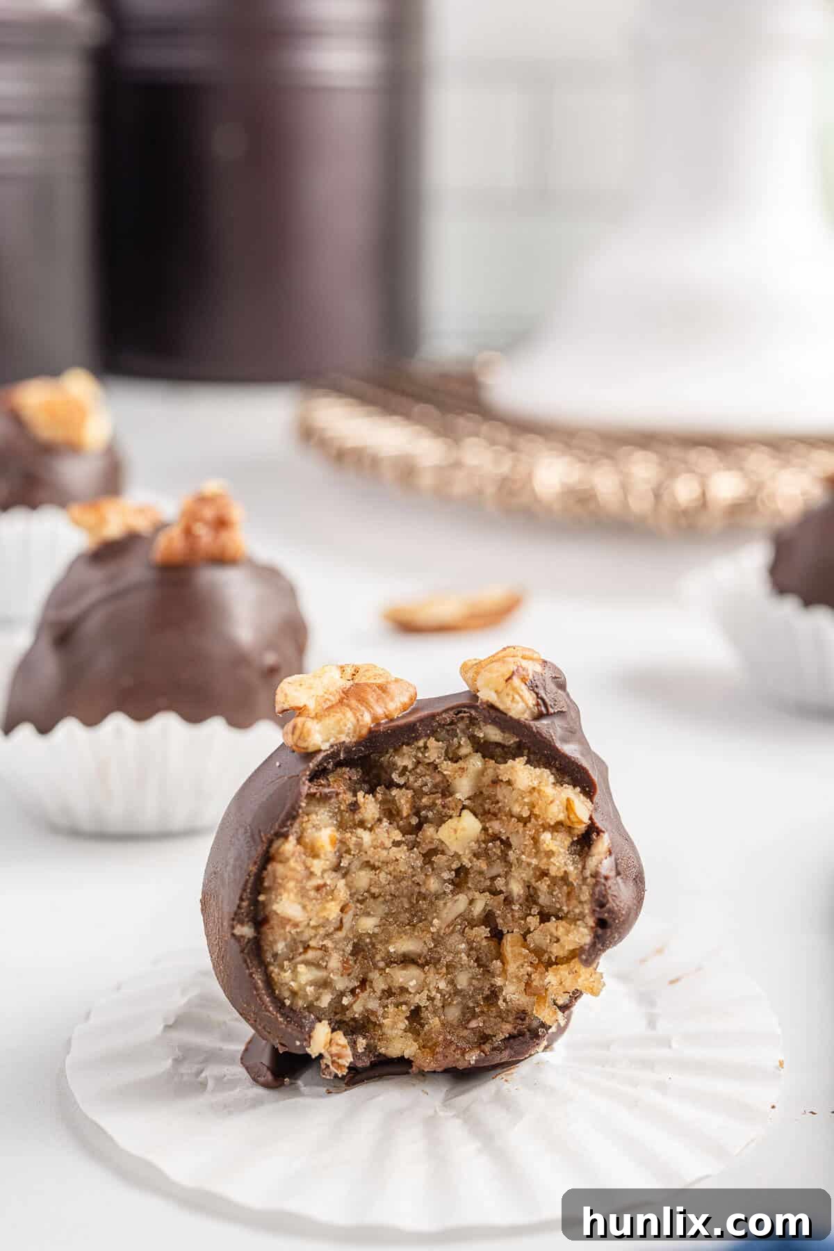 Pecan Pie Truffles 11 A pecan pie ball cut in half, revealing the soft, nutty interior and chocolate coating.