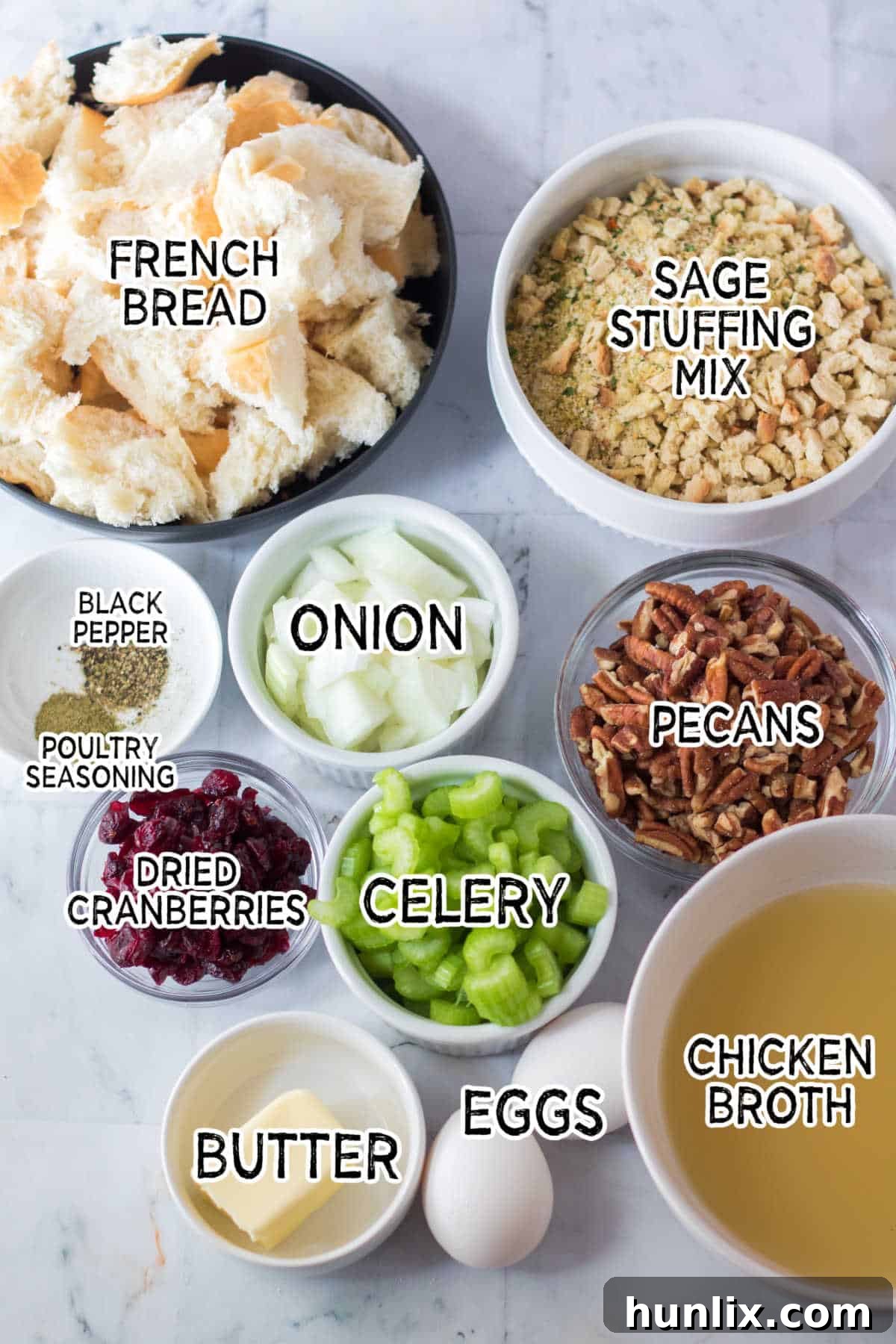 Effortless Slow Cooker Cranberry Pecan Stuffing 3 A selection of fresh ingredients laid out on a wooden surface, including chopped celery, onion, torn French bread, pecans, and dried cranberries, all ready for the stuffing recipe.