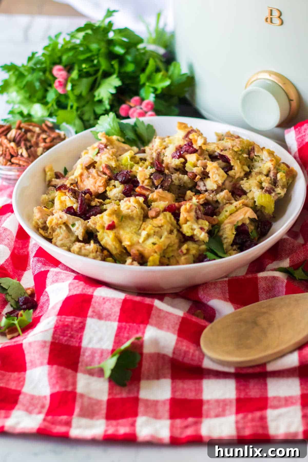 Effortless Slow Cooker Cranberry Pecan Stuffing 7 A bowl of cranberry pecan stuffing beautifully presented in front of a slow cooker, illustrating a serving suggestion.