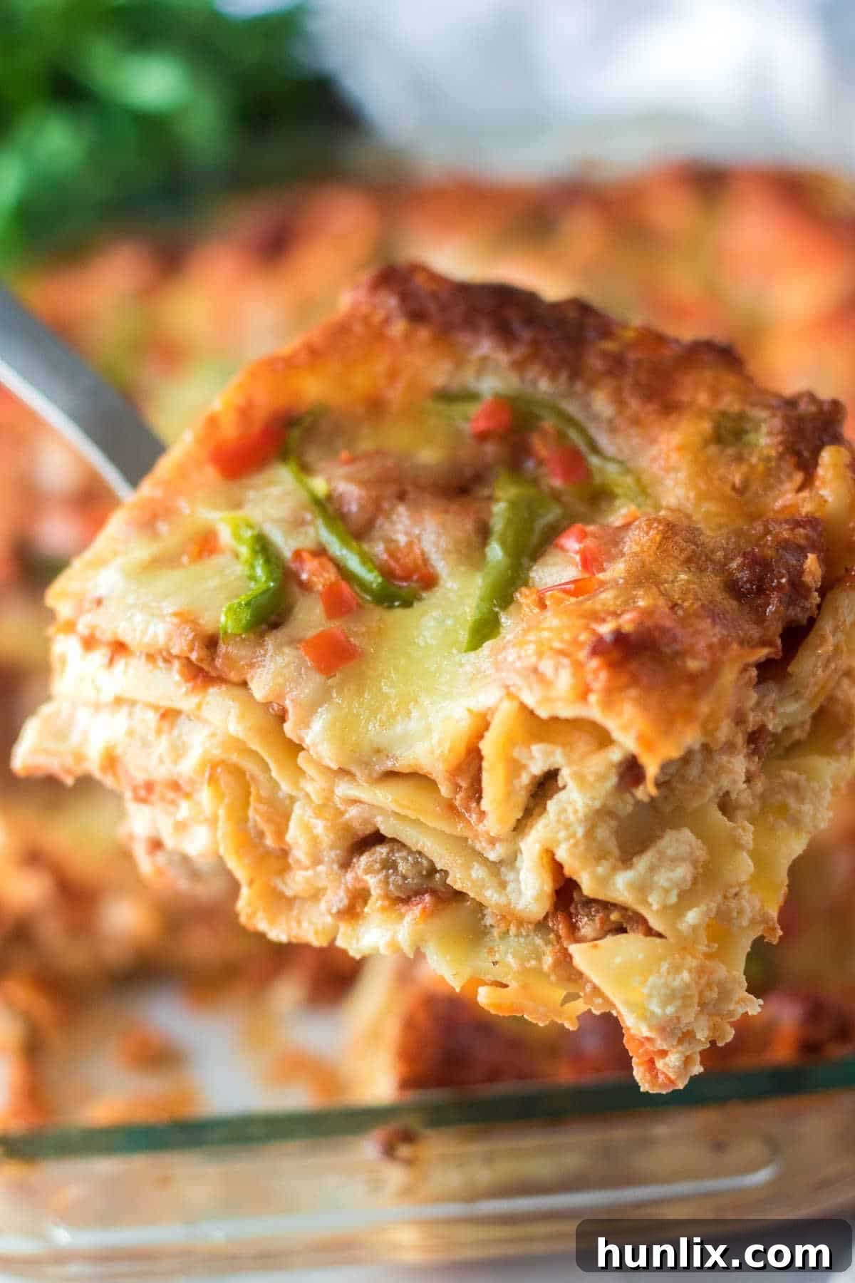 Festive Lasagna Delight 8 A slice of golden brown Christmas lasagna on a spatula, showing the distinct layers of meat, cheese, and noodles.