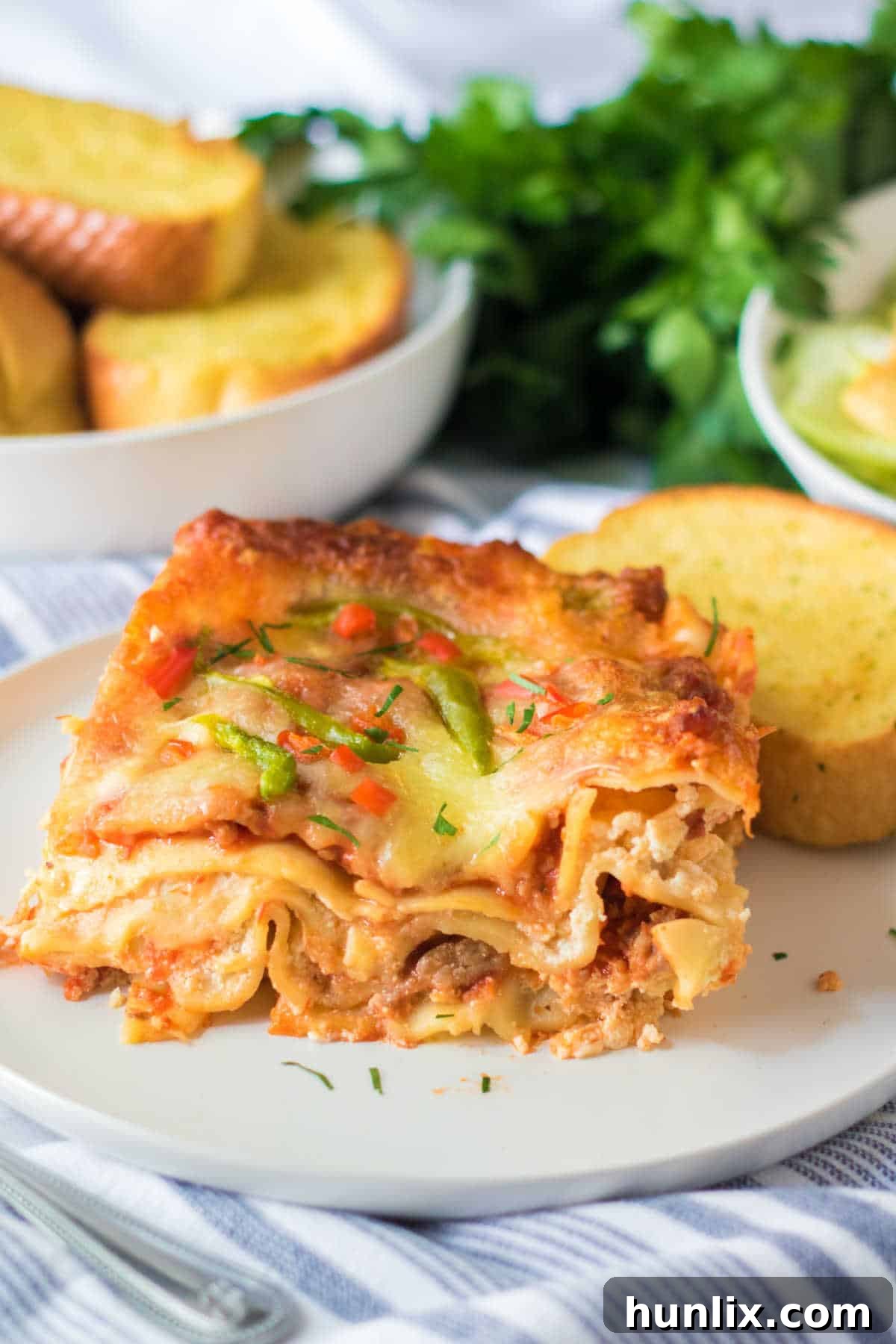 Festive Lasagna Delight 9 A serving of Christmas lasagna on a plate, accompanied by a slice of garlic toast.