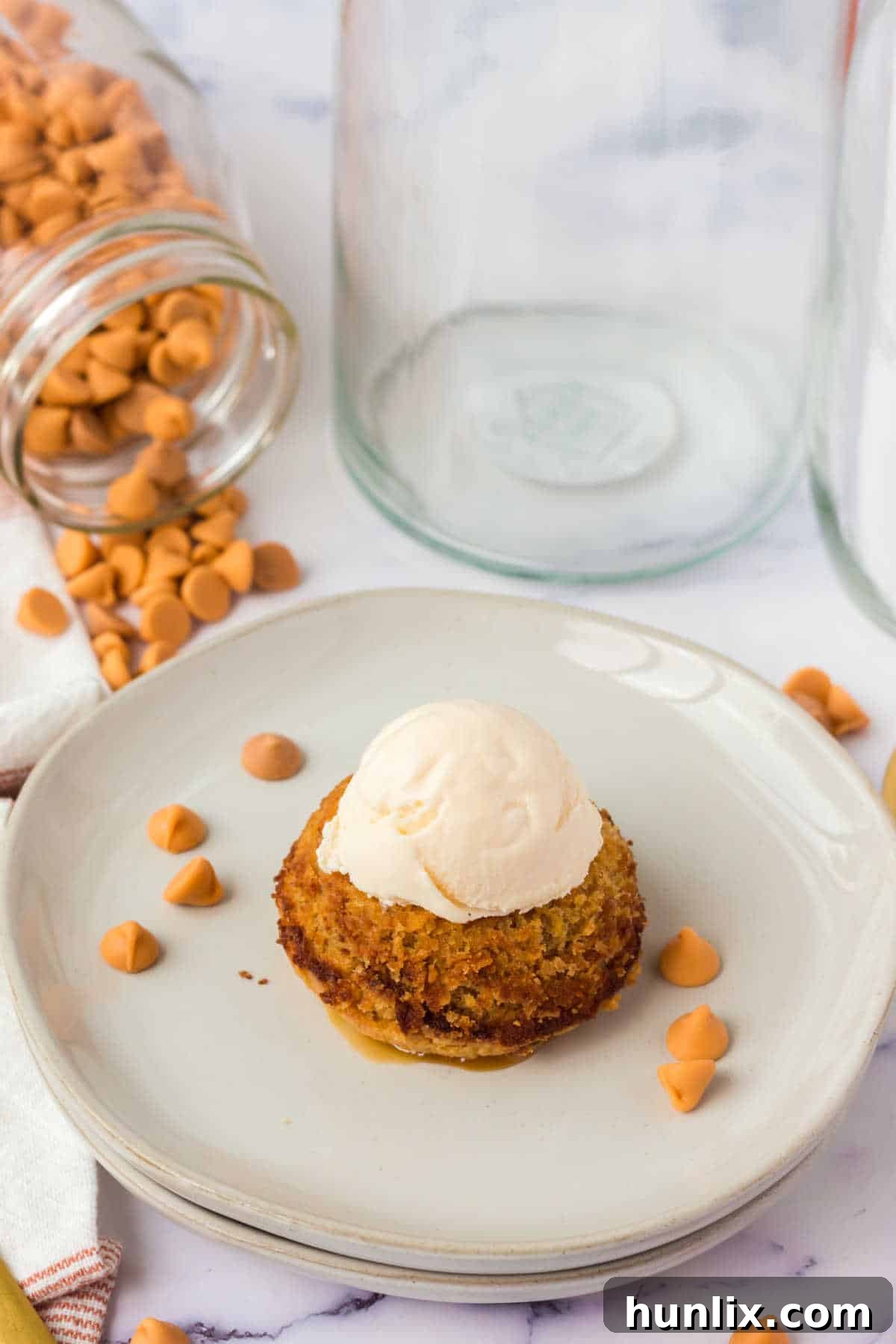 Molten Butterscotch Delights 2 A butterscotch lava cake on a plate topped with a scoop of vanilla ice cream.