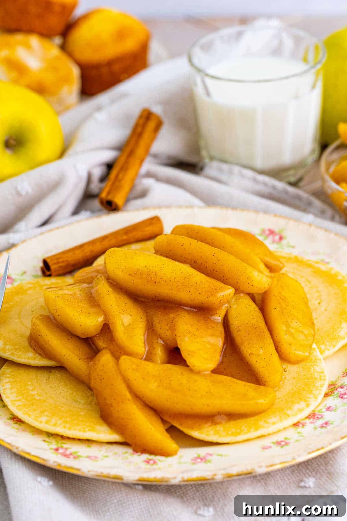 Warm, glistening fried apples arranged on top of fluffy pancakes, illustrating a delicious way to serve this comforting dish for breakfast or brunch.