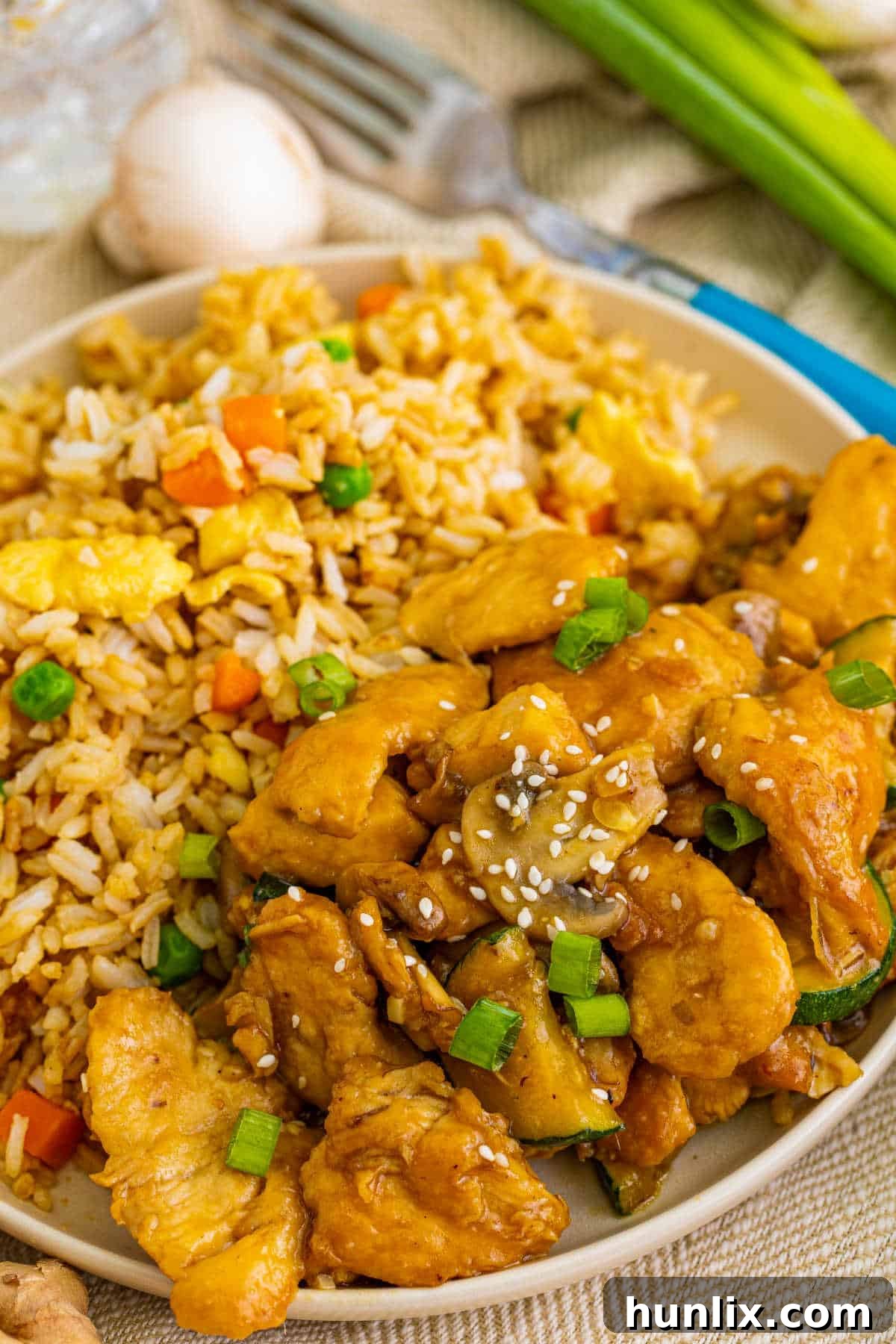 Panda express mushroom chicken on a plate with fried rice.