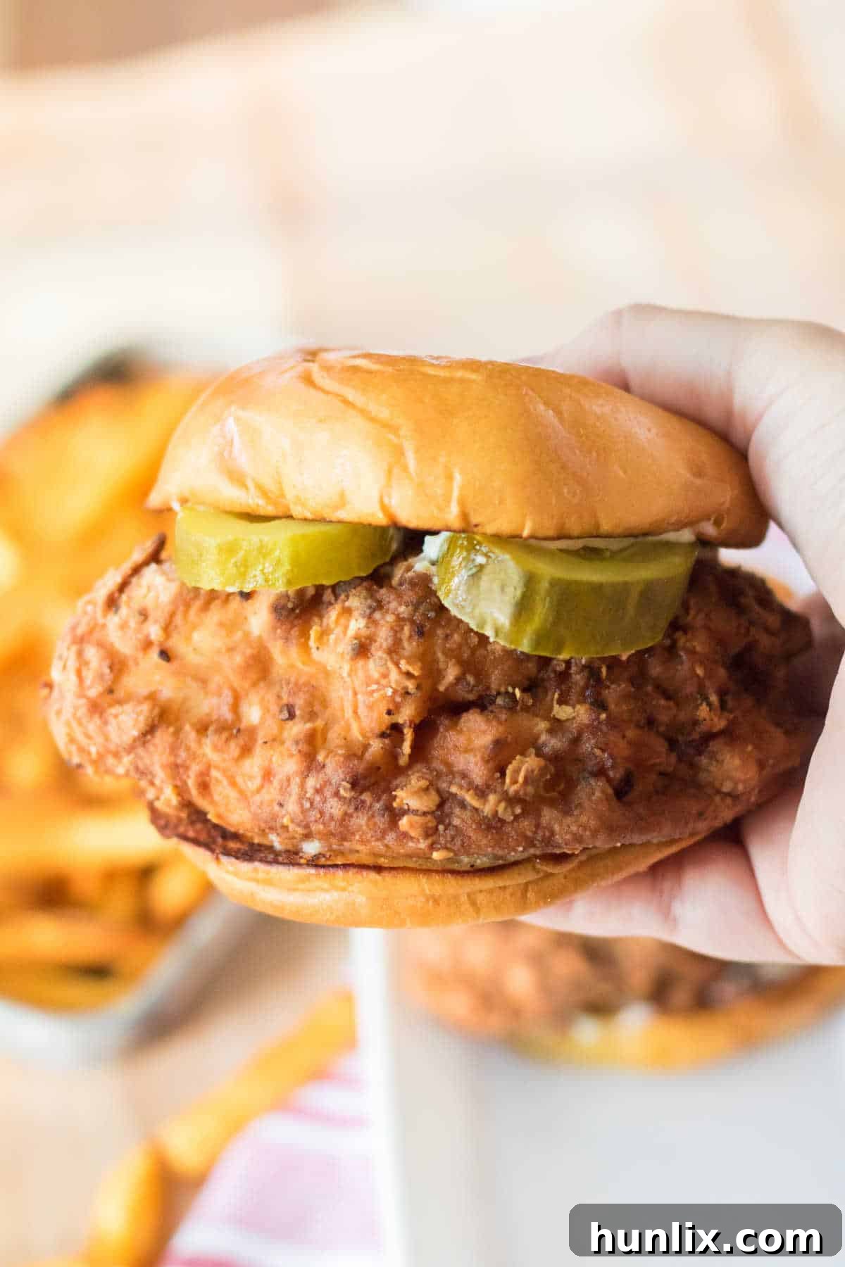 Homemade Popeyes Chicken Sandwich 8 A hand holding a Copycat Popeye's Chicken Sandwich.