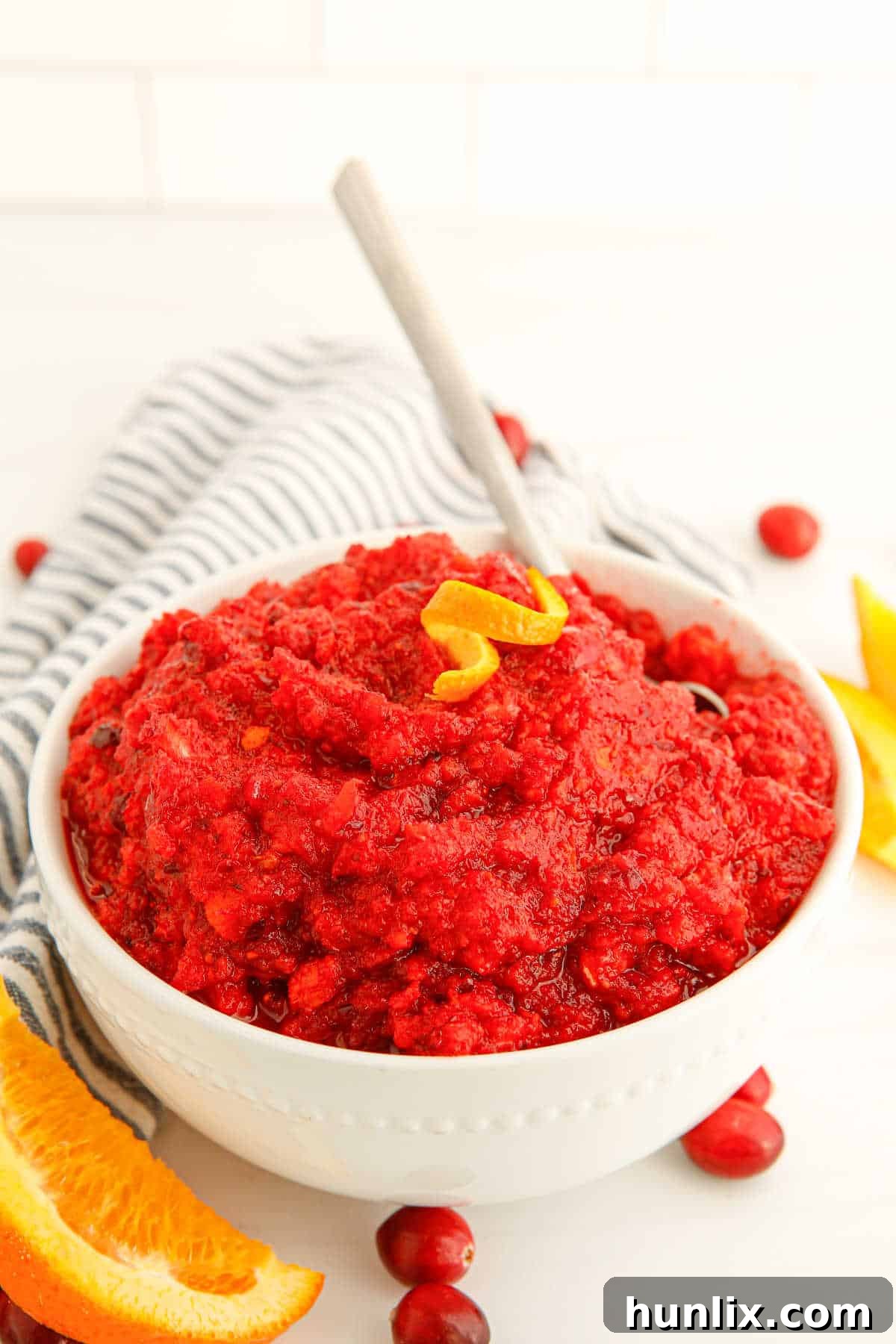 A beautifully presented bowl of homemade cranberry relish with a serving spoon, ready for a holiday meal.