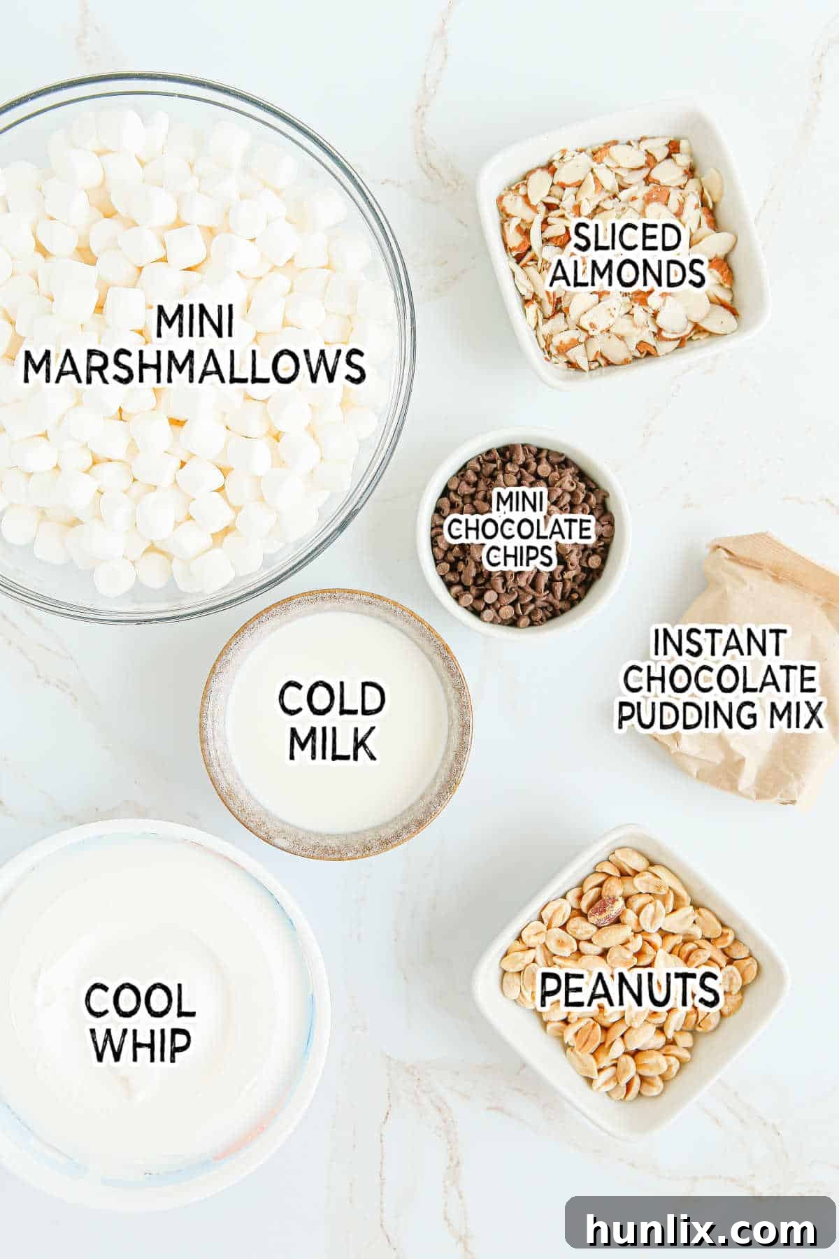 Decadent Rocky Road Dream 3 All the ingredients neatly laid out for making Rocky Road Fluff: pudding mix, milk, Cool Whip, marshmallows, chocolate chips, peanuts, and almonds.