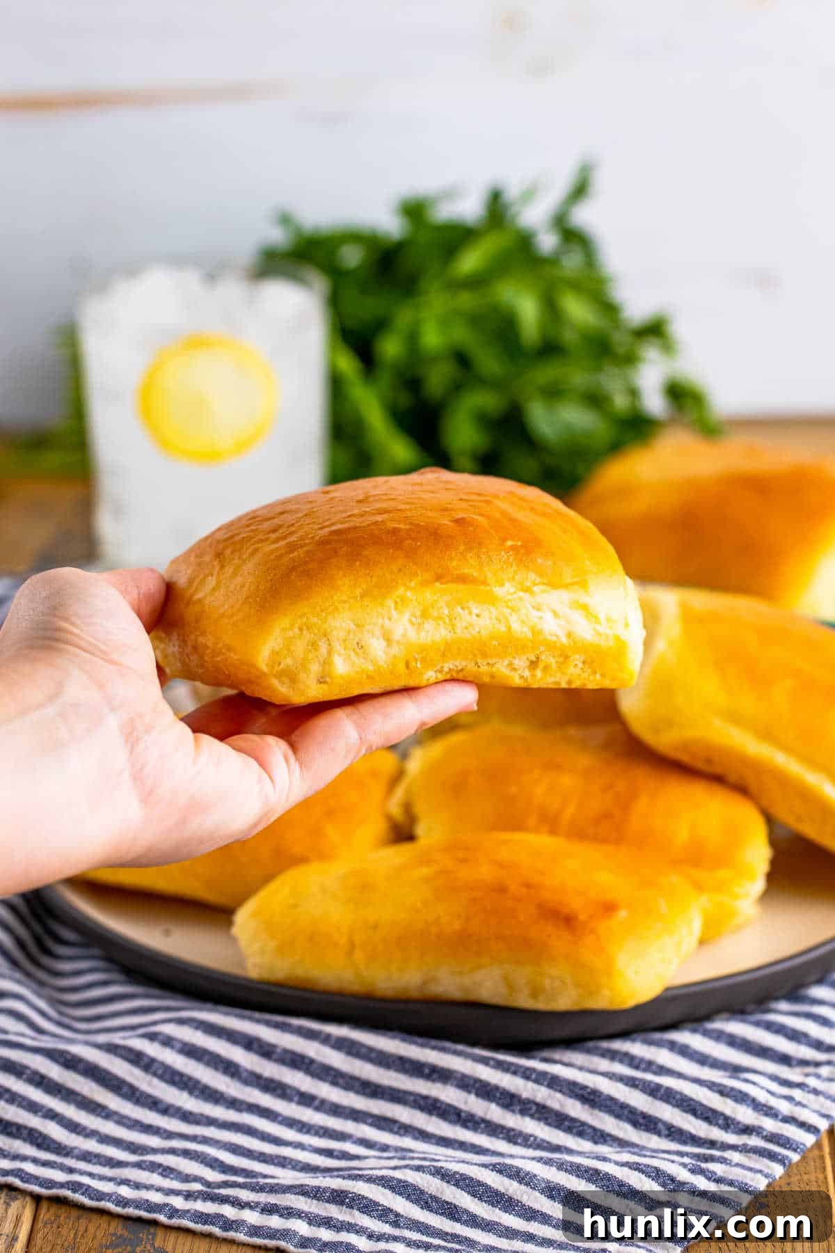 A hand holding a warm, fluffy Texas Roadhouse roll, ready to be enjoyed.