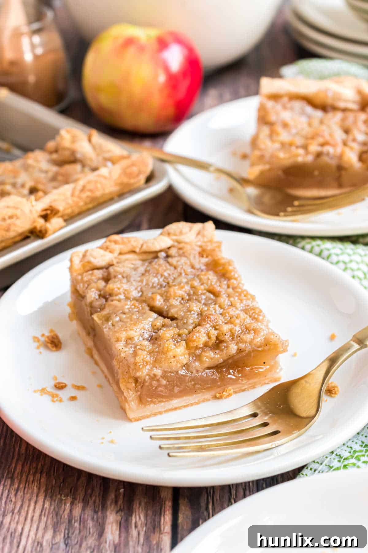 Sheet Pan Apple Pie 11 A slice of apple slab pie elegantly placed on a plate with a fork, showing the delicious layers.
