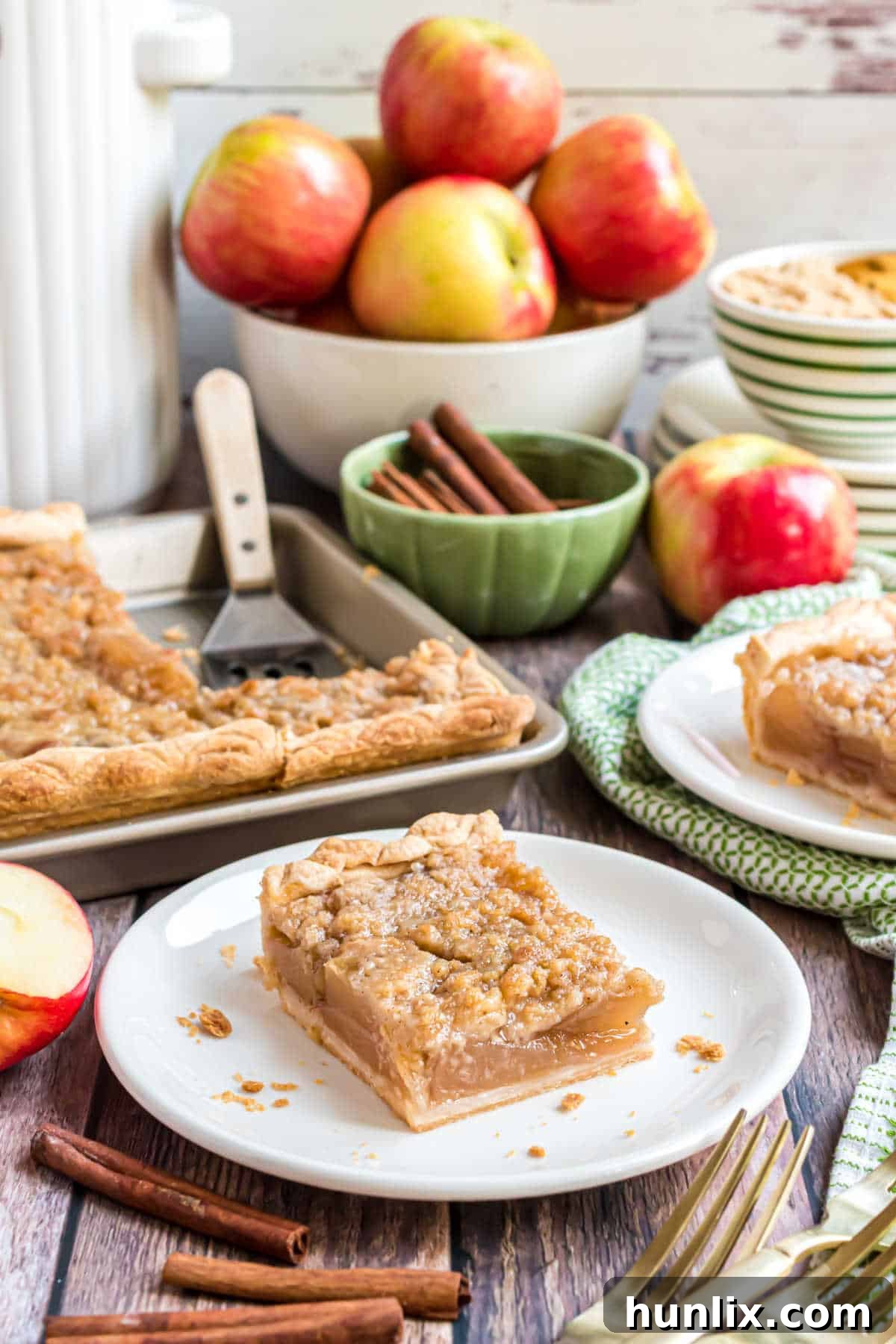 Sheet Pan Apple Pie 10 A perfectly portioned slice of apple slab pie on a white plate, ready to be enjoyed.