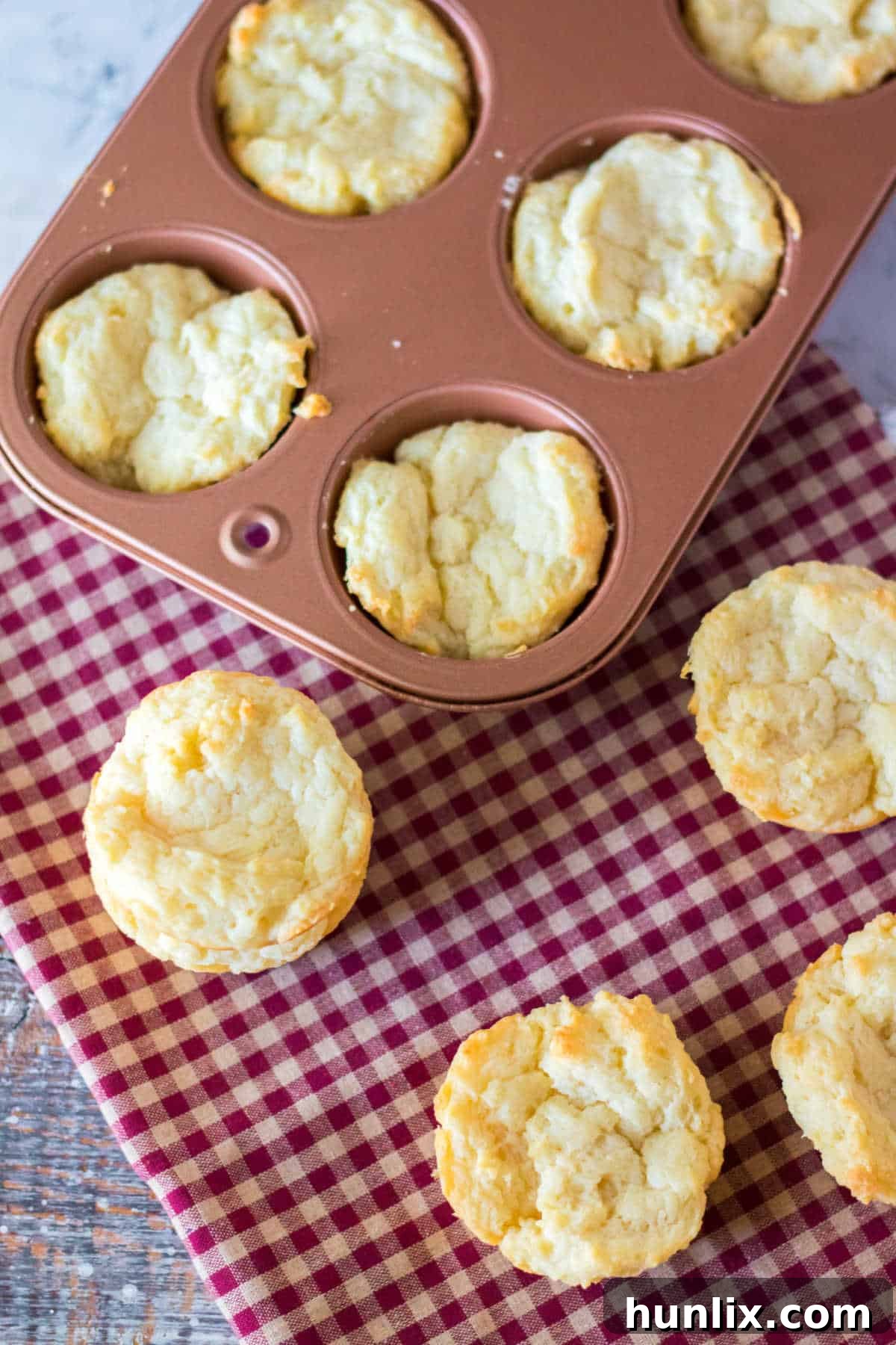 Sour cream biscuits baked to golden perfection in a muffin pan, ready to be served.