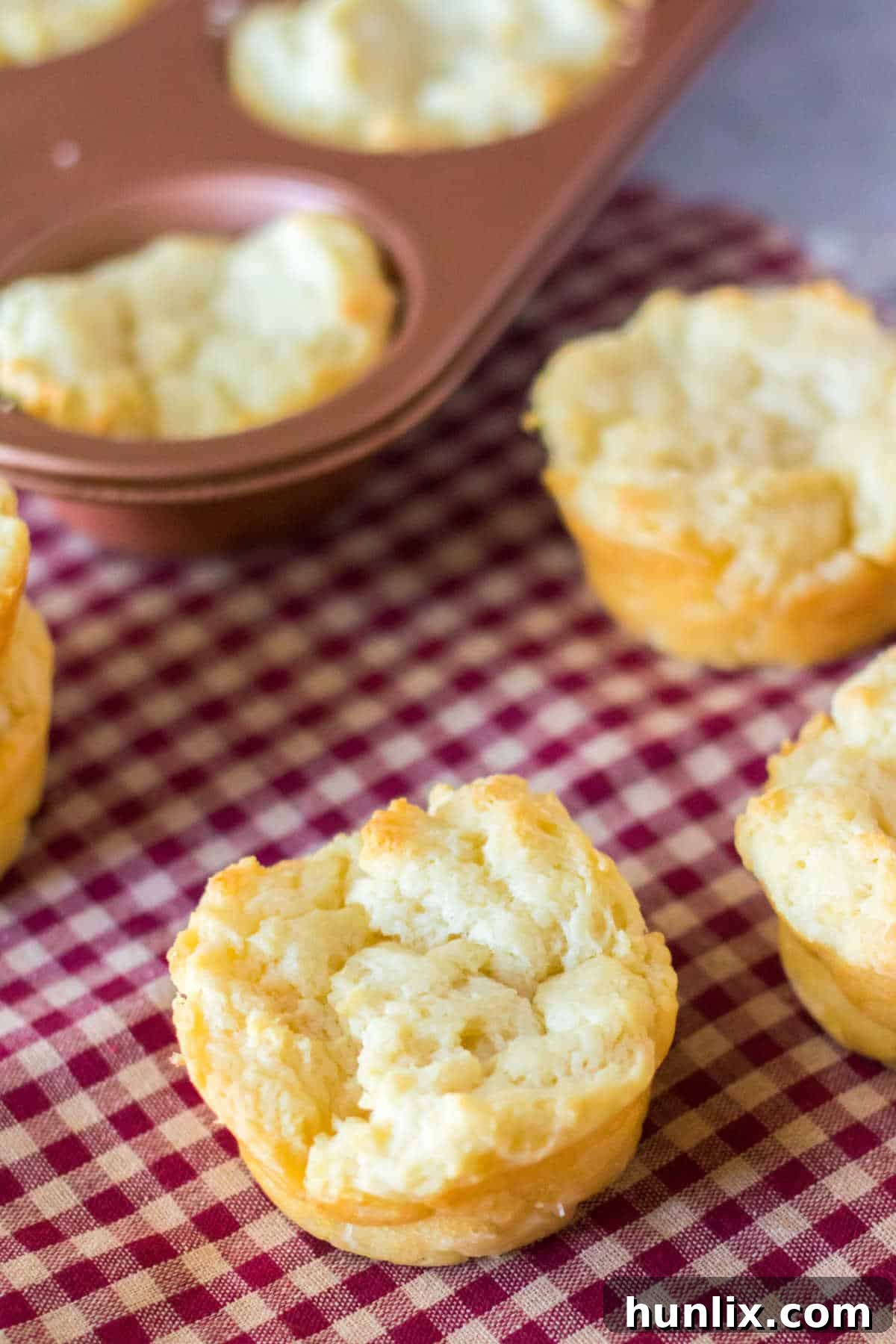 Beautifully golden sour cream biscuits presented on a red and white linen, showcasing their inviting texture.