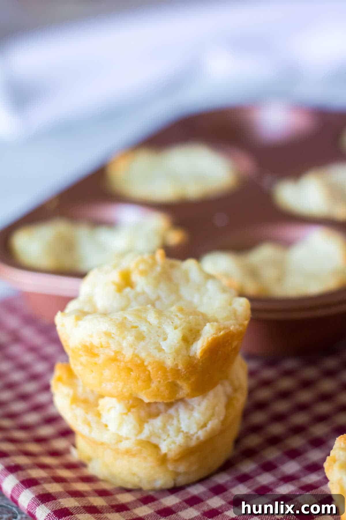A beautifully stacked pile of golden brown sour cream biscuits, highlighting their soft texture and inviting appearance.