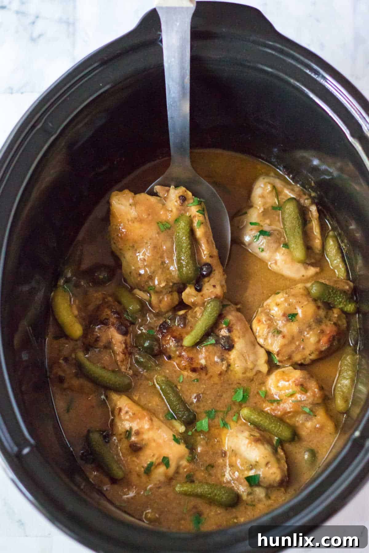 Dill Pickle Slow Cooker Chicken 2 Pickle chicken in a crockpot with a serving spoon.