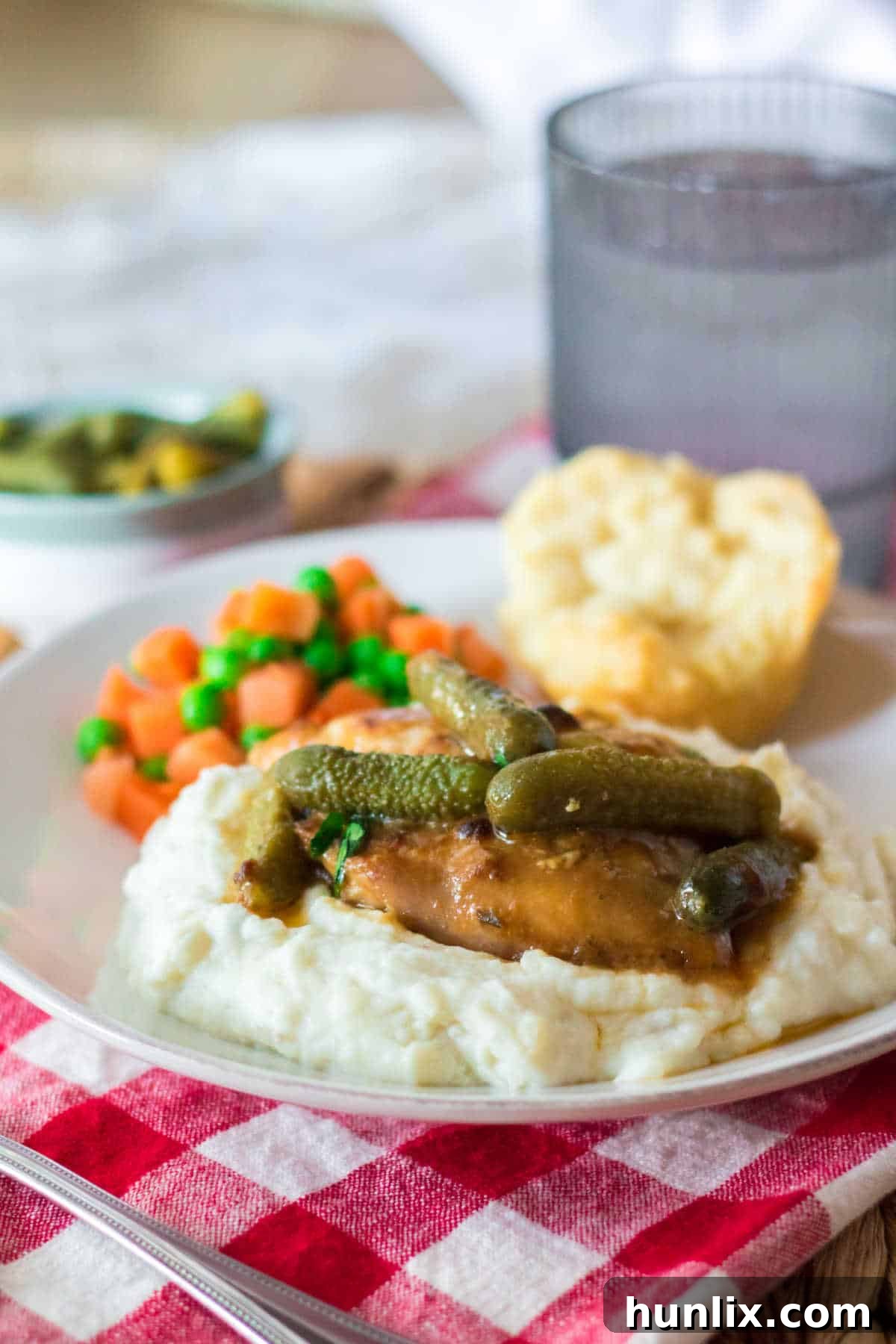 Dill Pickle Slow Cooker Chicken 6 Pickle chicken on mashed potatoes on a plate.