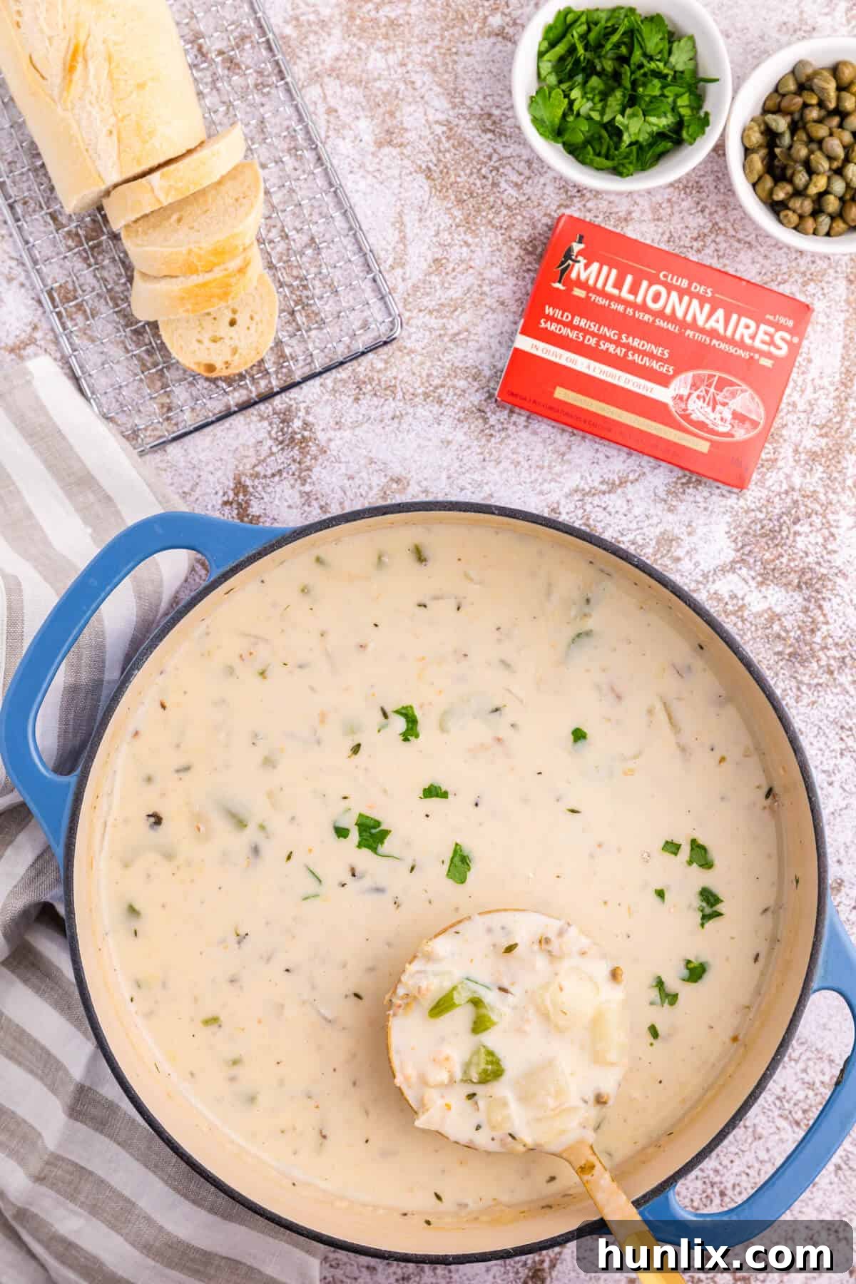 Coastal Comfort Chowder 2 A large pot of creamy homemade seafood chowder with a ladle resting inside, ready to be served. The rich, thick broth is visible, packed with various seafood pieces.