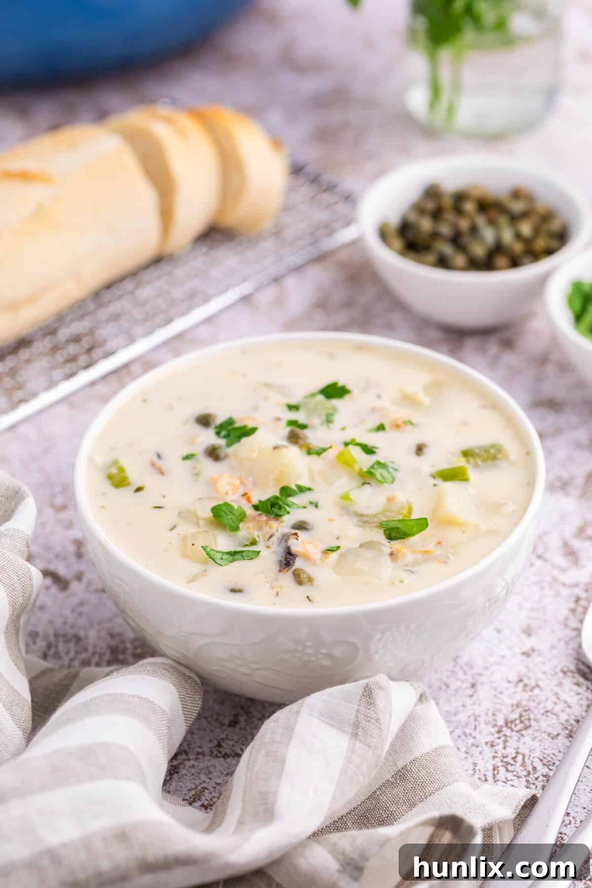Coastal Comfort Chowder 4 A pristine white bowl filled with creamy seafood chowder, garnished with fresh parsley, highlighting its inviting and hearty appearance.