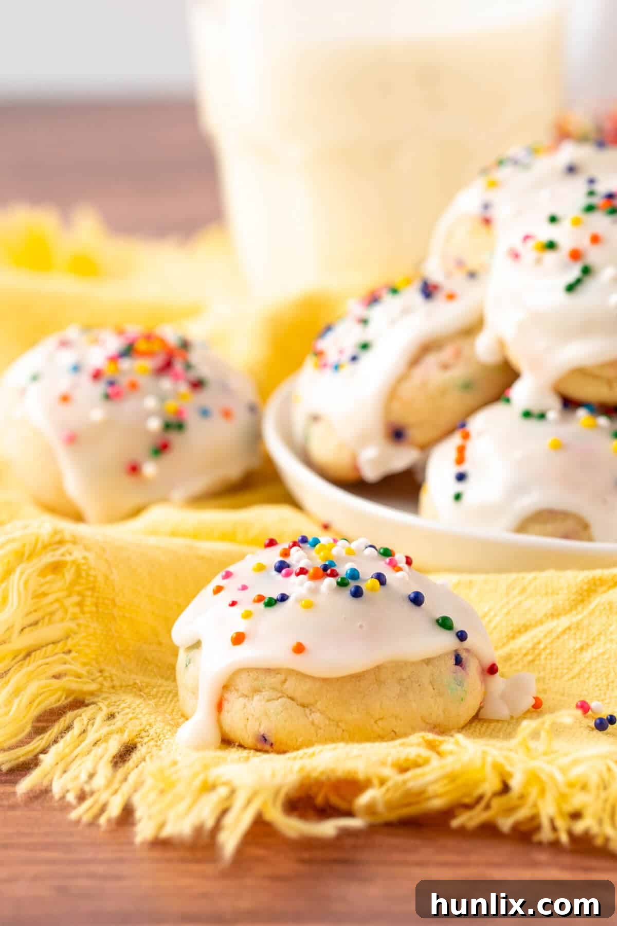 A single sweetened condensed milk cookie resting on a soft yellow linen, highlighting its delicate crumb and appealing texture.