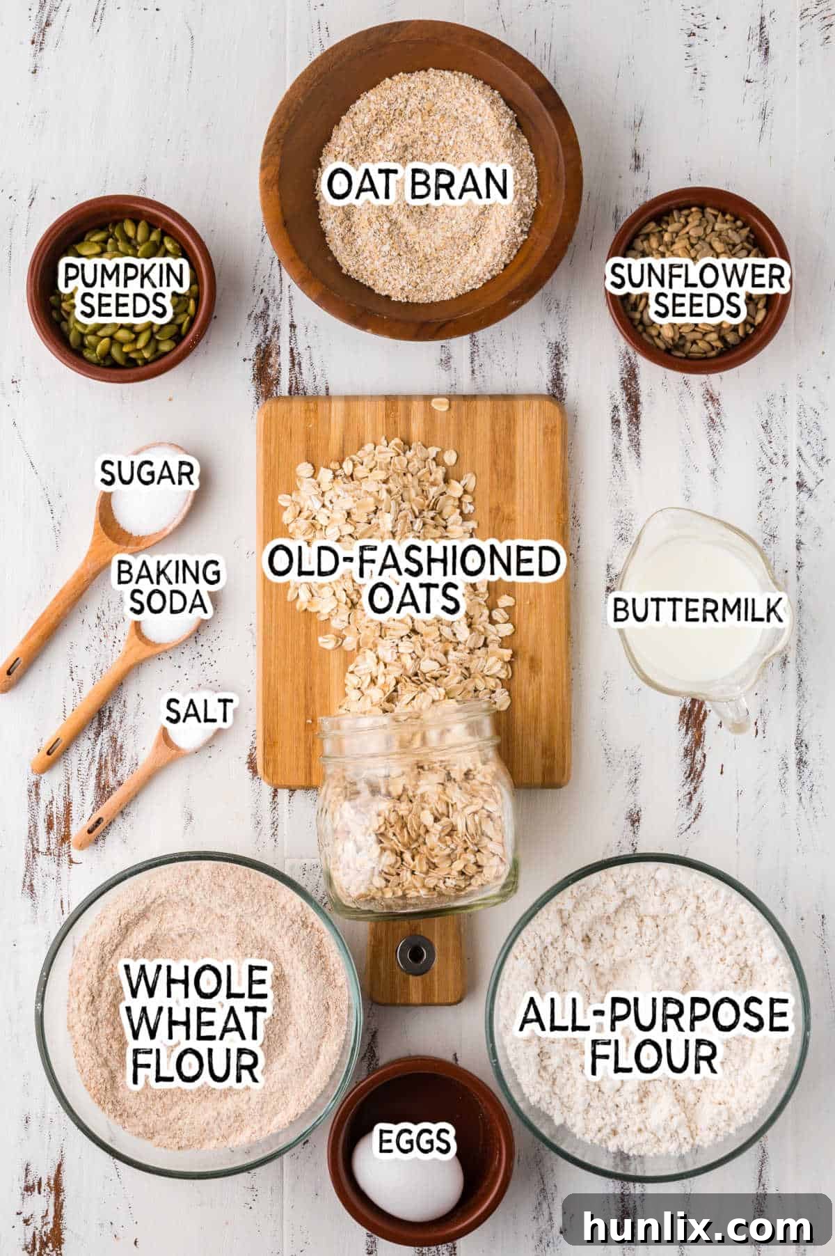 A selection of fresh ingredients laid out on a countertop, including flours, oats, seeds, eggs, and buttermilk, ready to be combined for Irish brown bread.