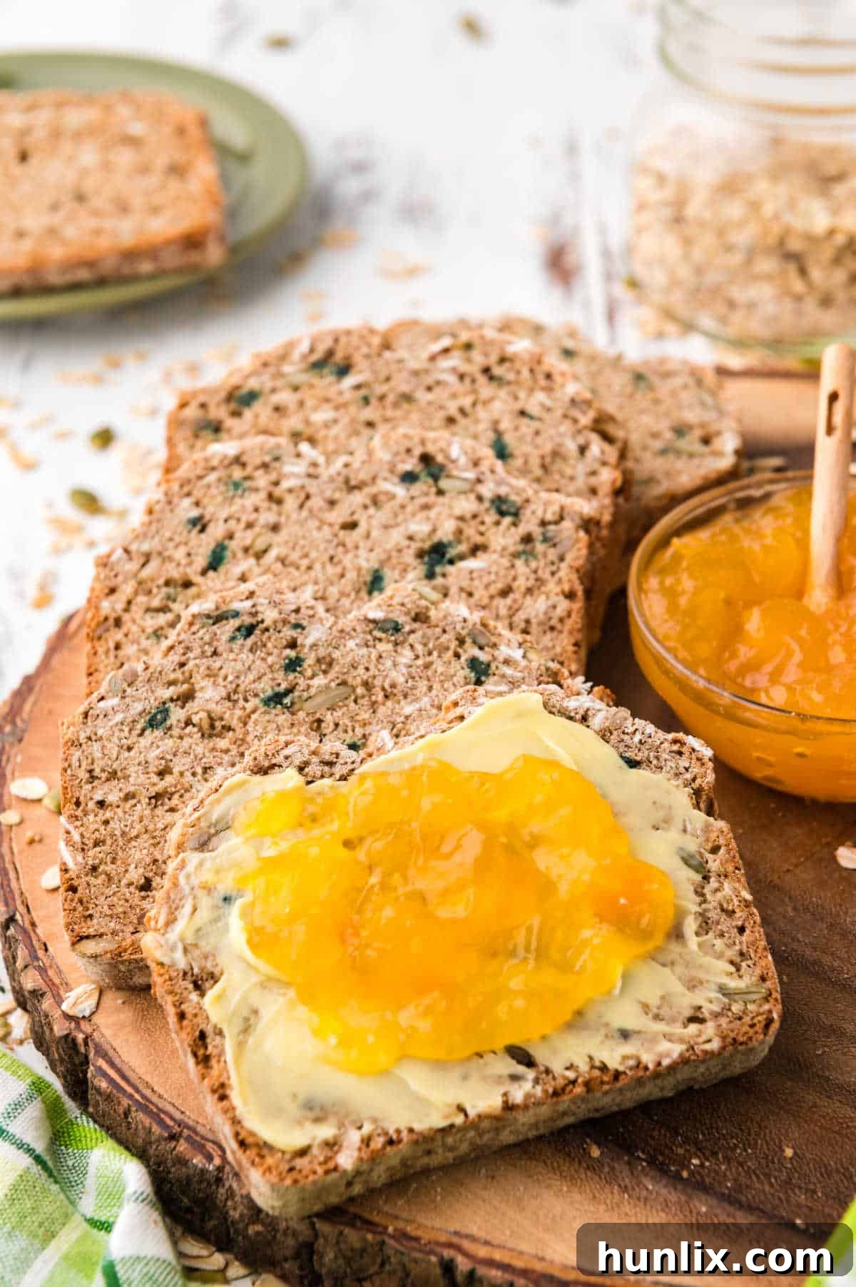 Two slices of Irish brown bread, one topped with rich butter and the other with vibrant orange marmalade, ready to be enjoyed.
