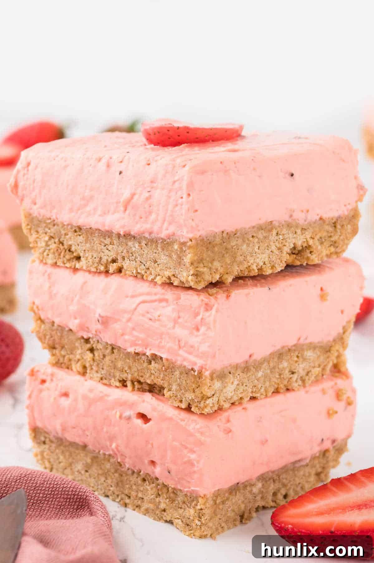 A neatly stacked pile of Strawberry Cheesecake Bars, showcasing their layers and delicious appearance.