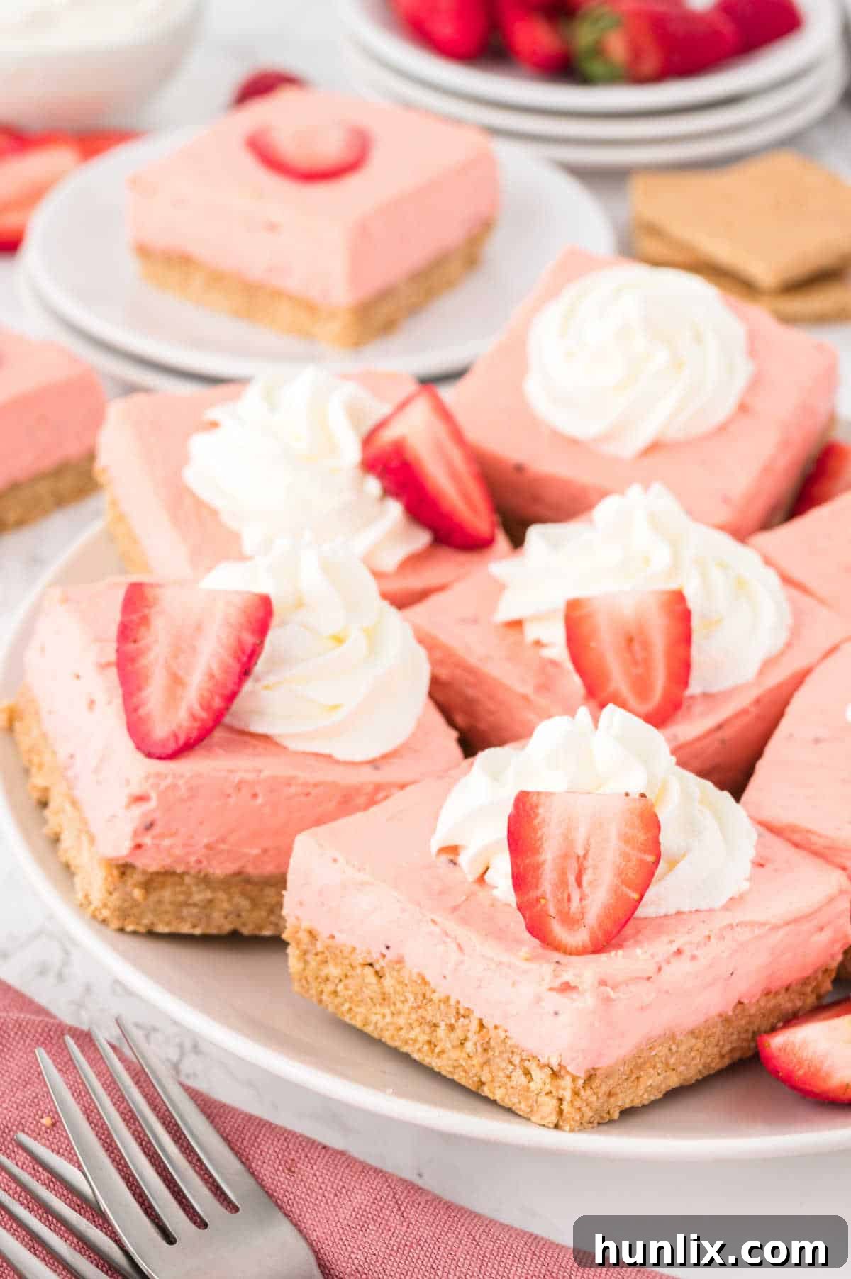A beautifully arranged plate of strawberry cheesecake bars, ready to be enjoyed.