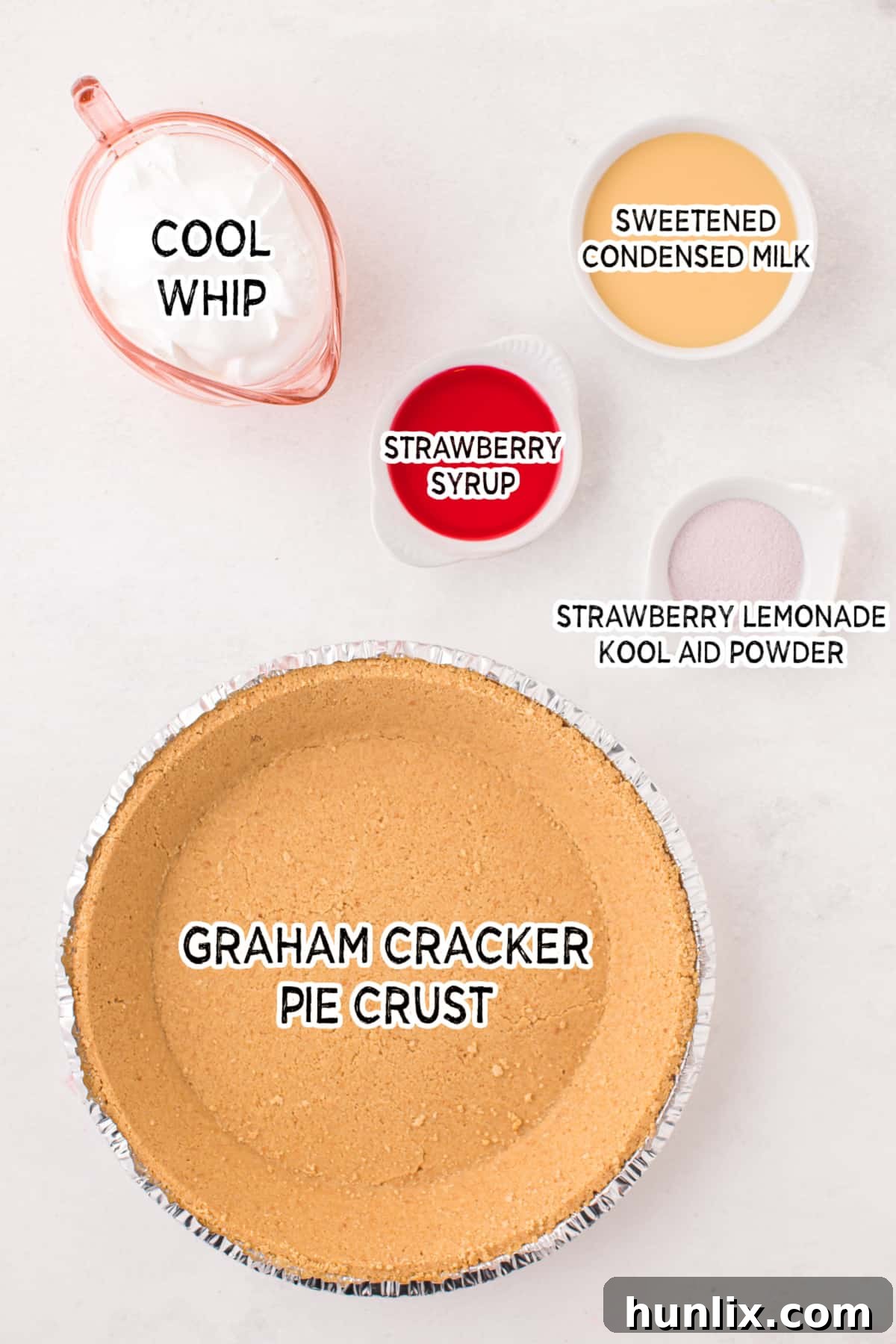 Neon Nectar Pie 3 A vibrant collection of ingredients laid out, including sweetened condensed milk, strawberry syrup, Kool-Aid powder, whipped topping, and a graham cracker pie crust, ready for making Kool-Aid pie.