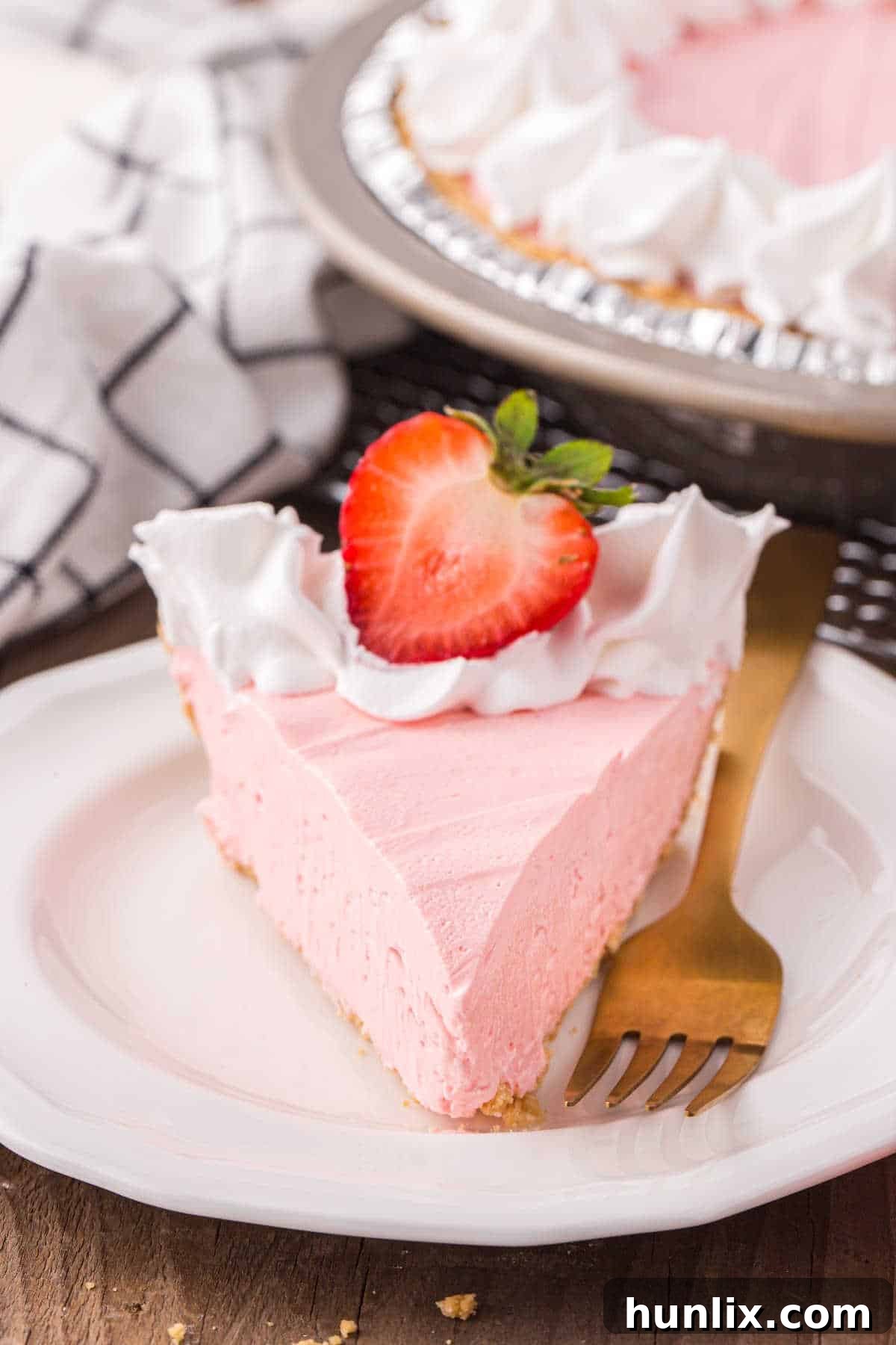 Neon Nectar Pie 8 A slice of Kool-Aid pie on a white plate with a fork, showing the distinct layers of creamy filling and graham cracker crust, ready to be enjoyed.