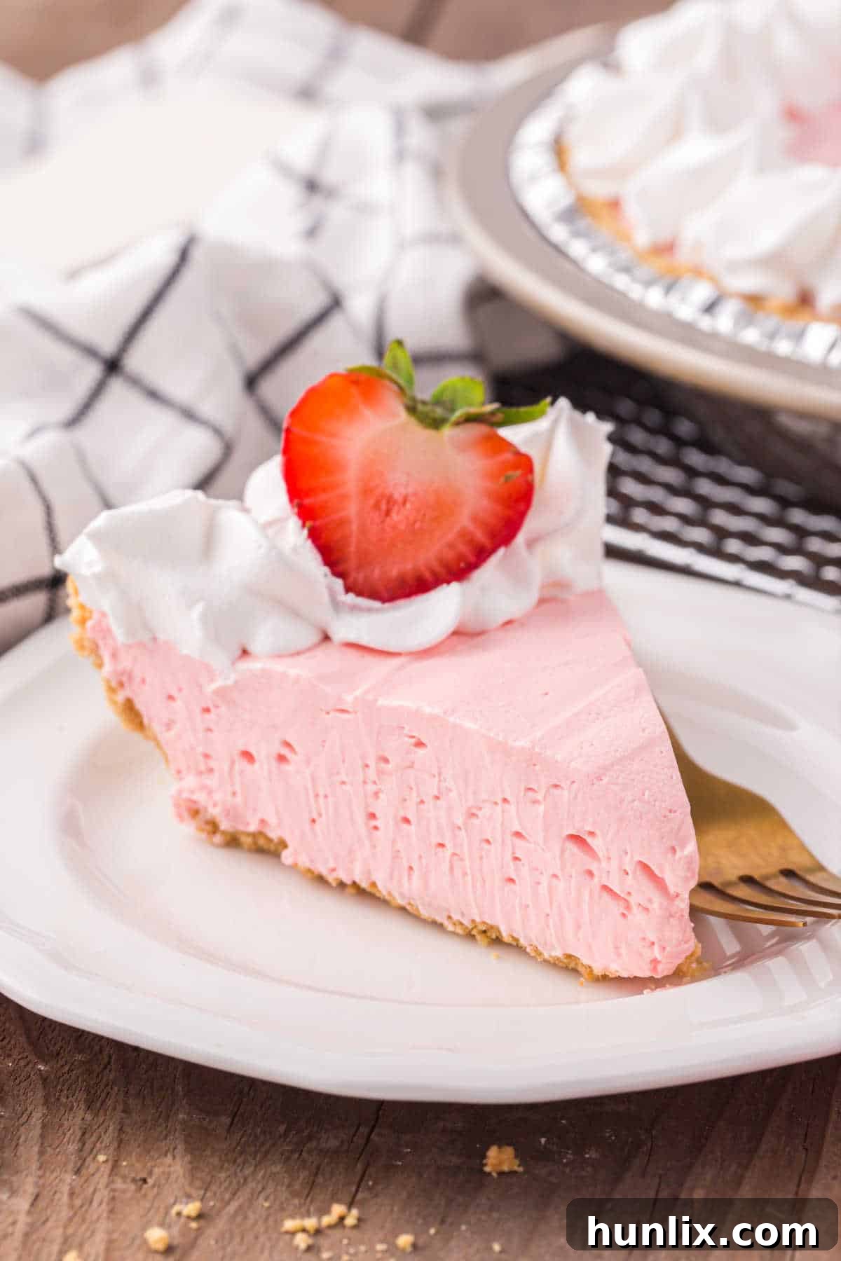 Neon Nectar Pie 9 A perfectly portioned slice of Kool-Aid pie on a white plate, highlighting its smooth texture and light pink color, with a fork poised to take a bite.