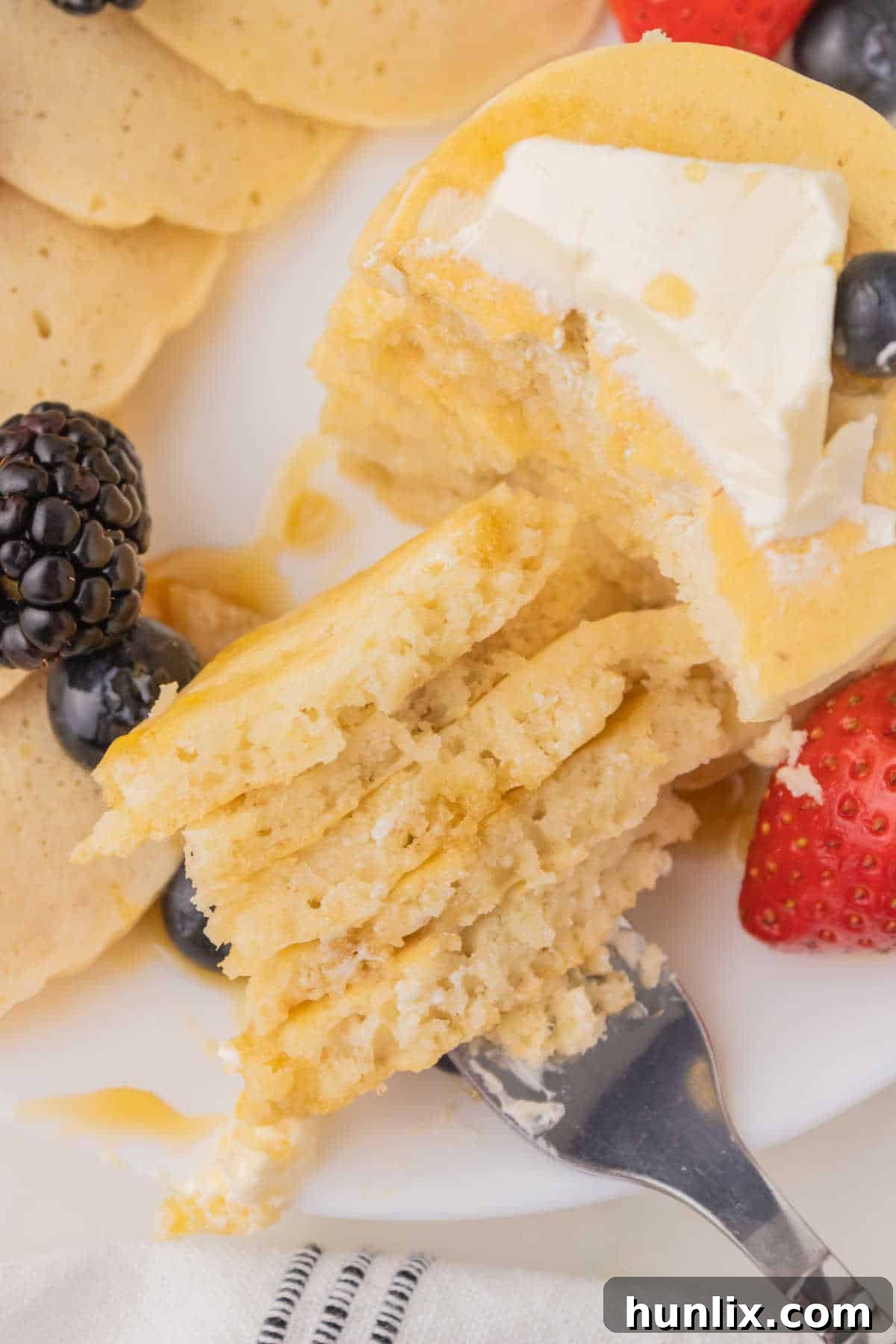 A fork with a bite of mini pancakes on them.